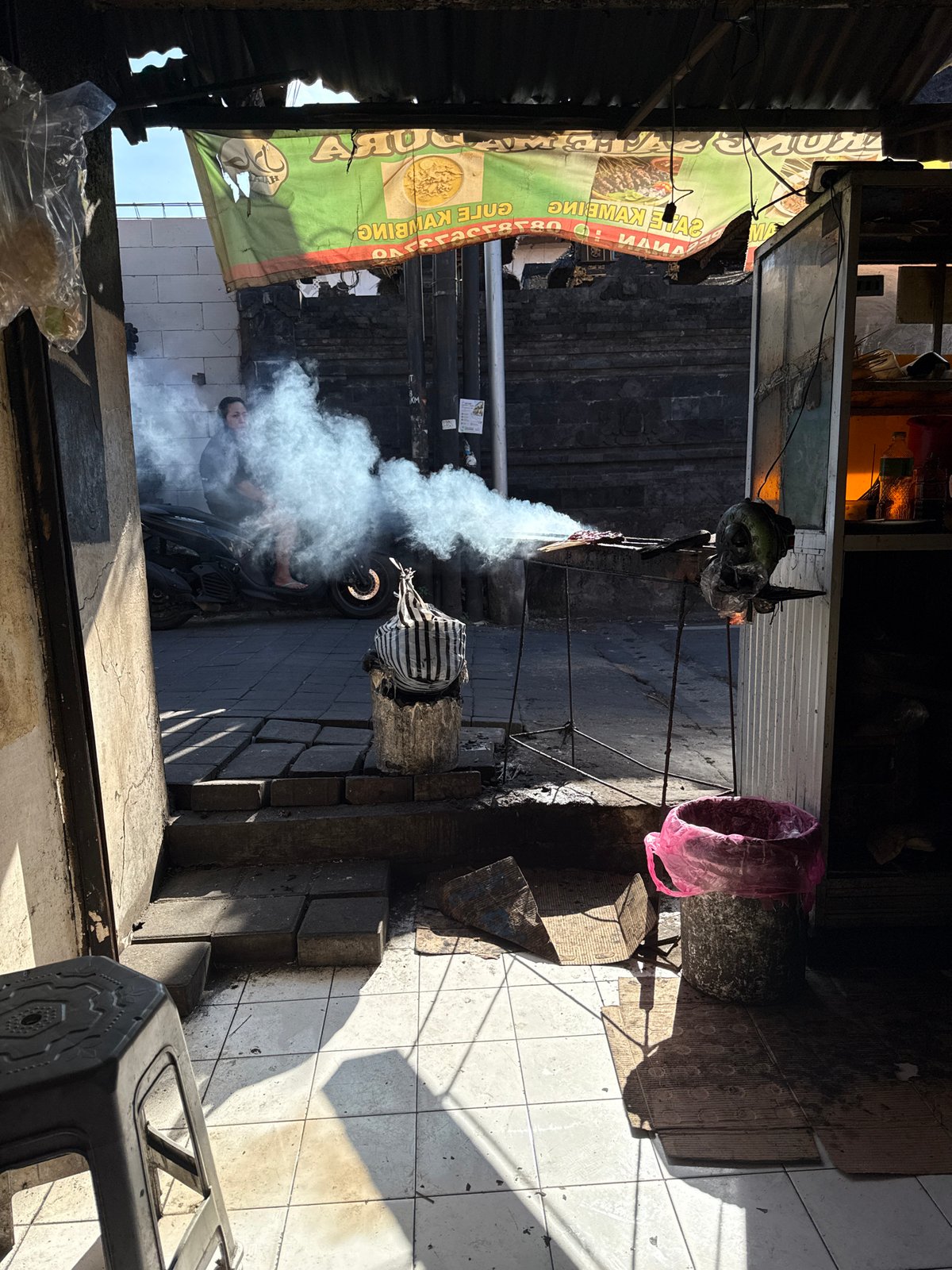 Street vendor cooks food from motorcycle setup in Kuta