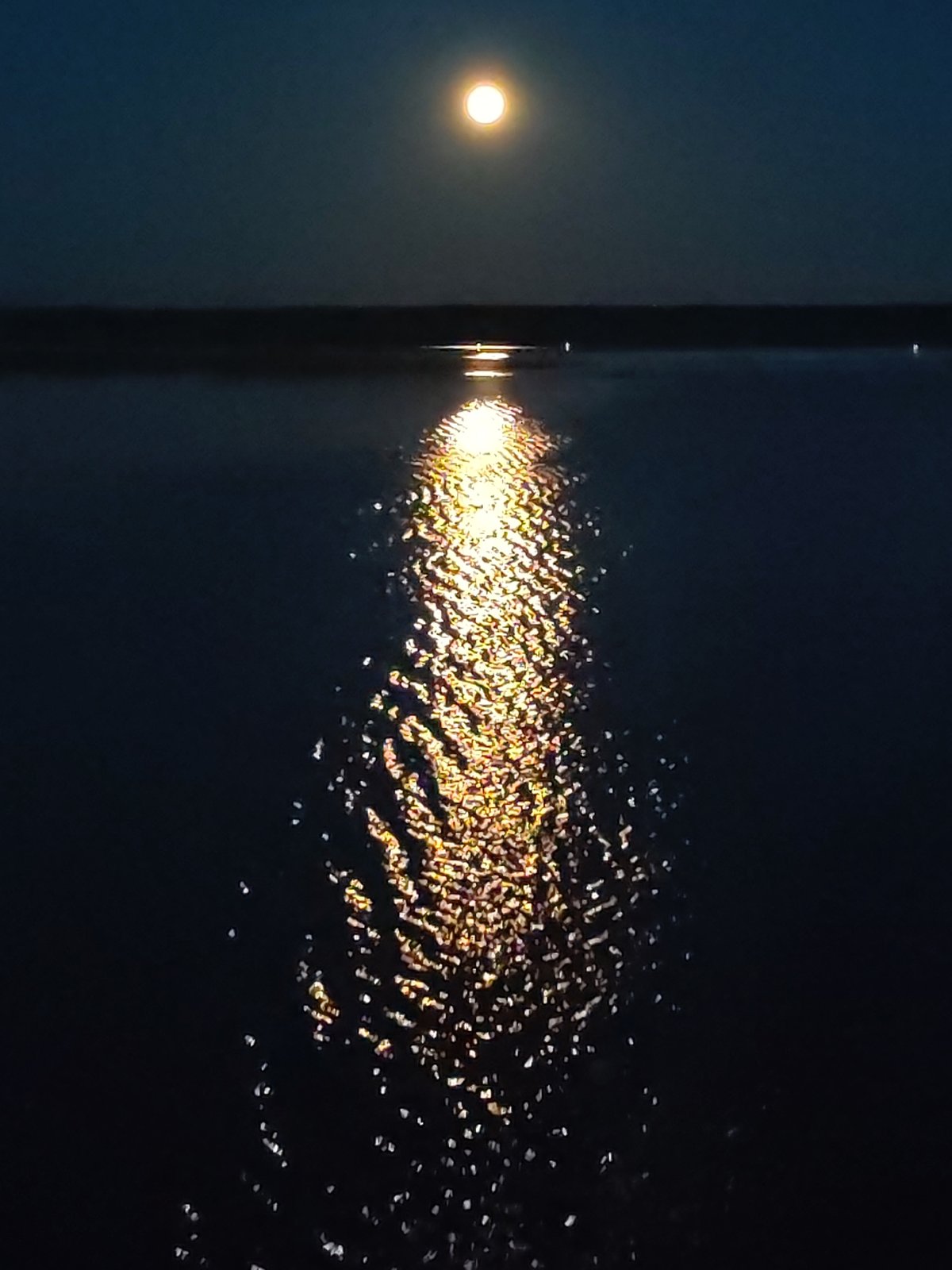 Moonlight creates golden reflection on Russian water body