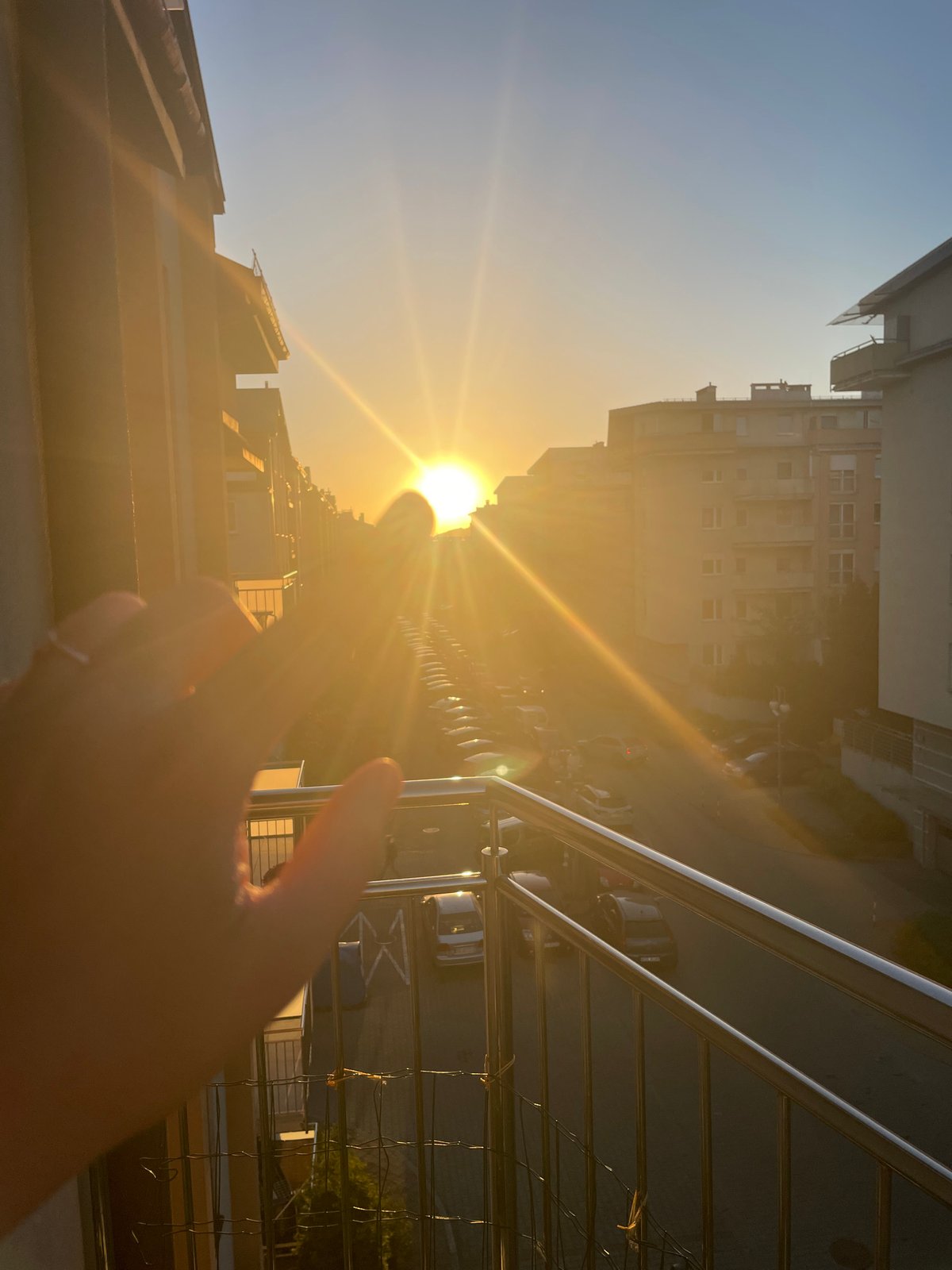 Urban sunset witnessed from multiple elevated viewpoints, hands gesturing skyward