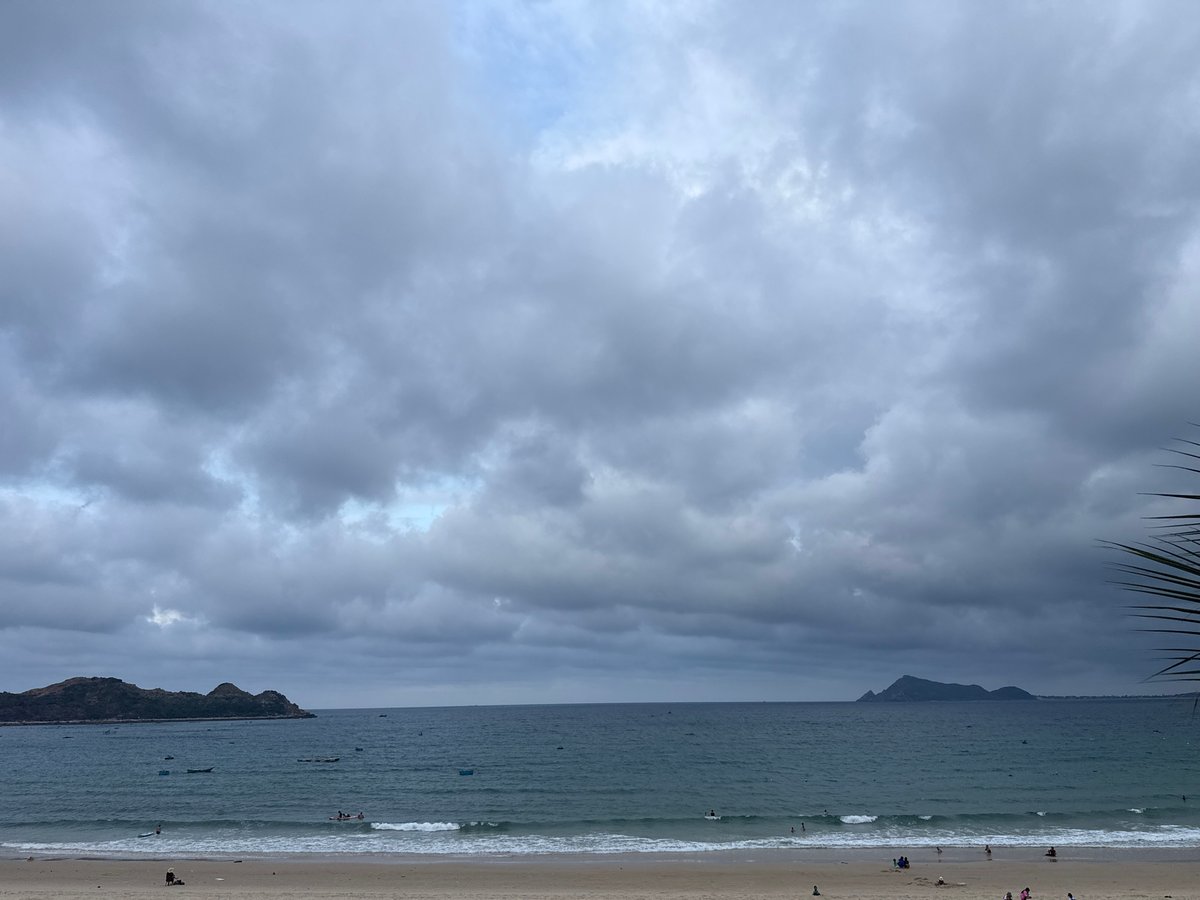 Quiet tropical beach, overcast morning, boats dotting calm water