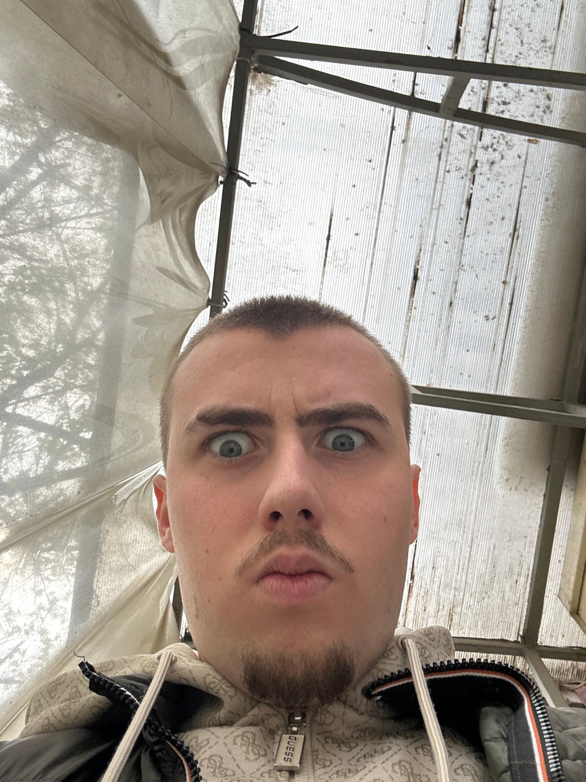 Man takes selfie in Sofia wearing Guess hoodie