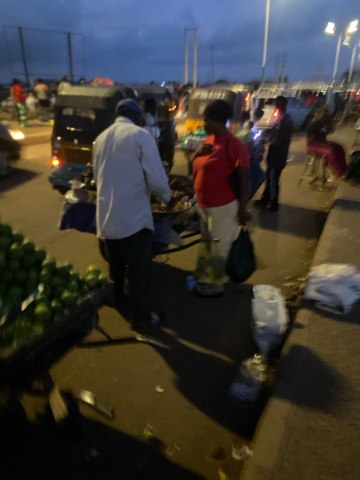 Evening street market bustles under streetlights in Bukuru Nigeria