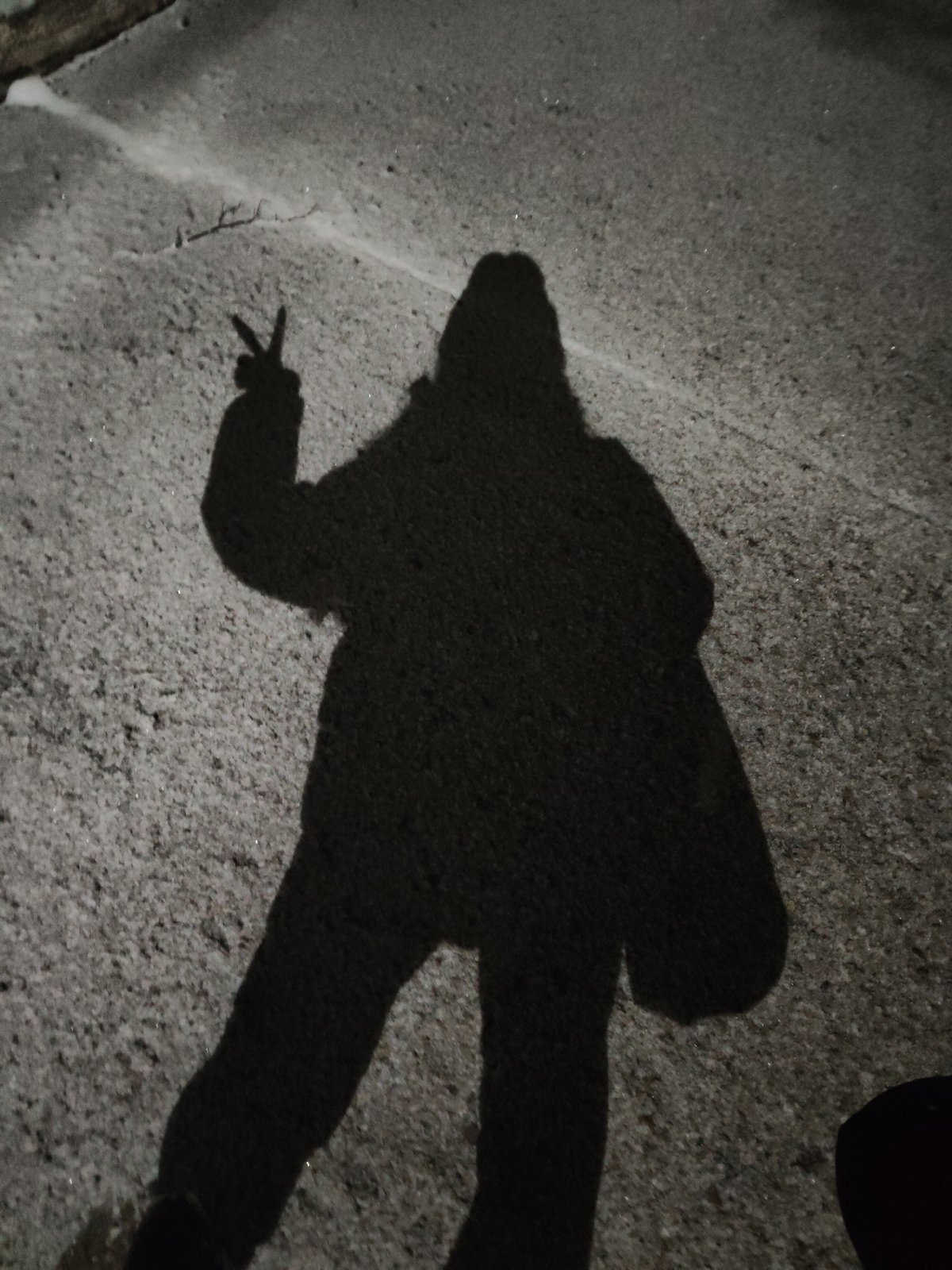 Person leaves footprints, heart drawing, peace sign shadow in snow