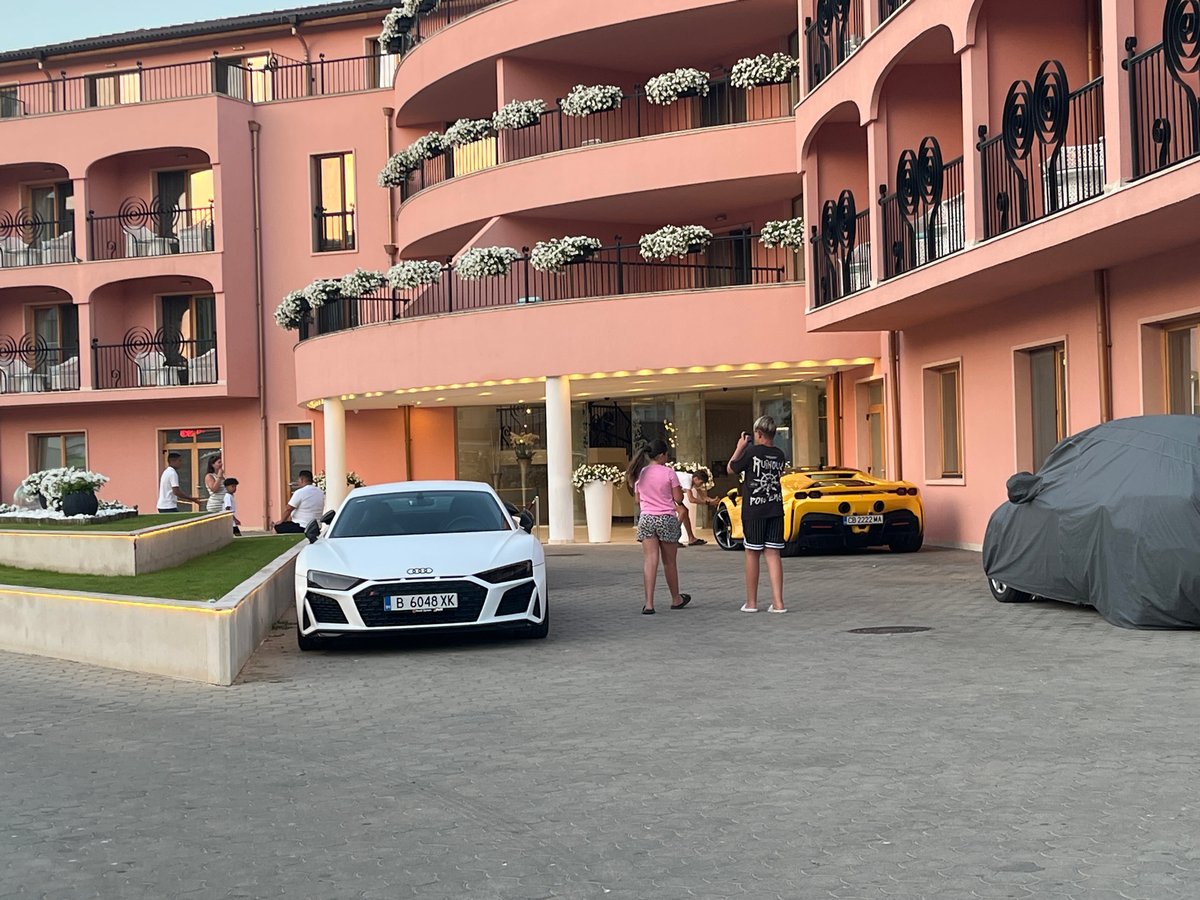 Nesebar beach and streets at dusk, with exotic cars nearby.