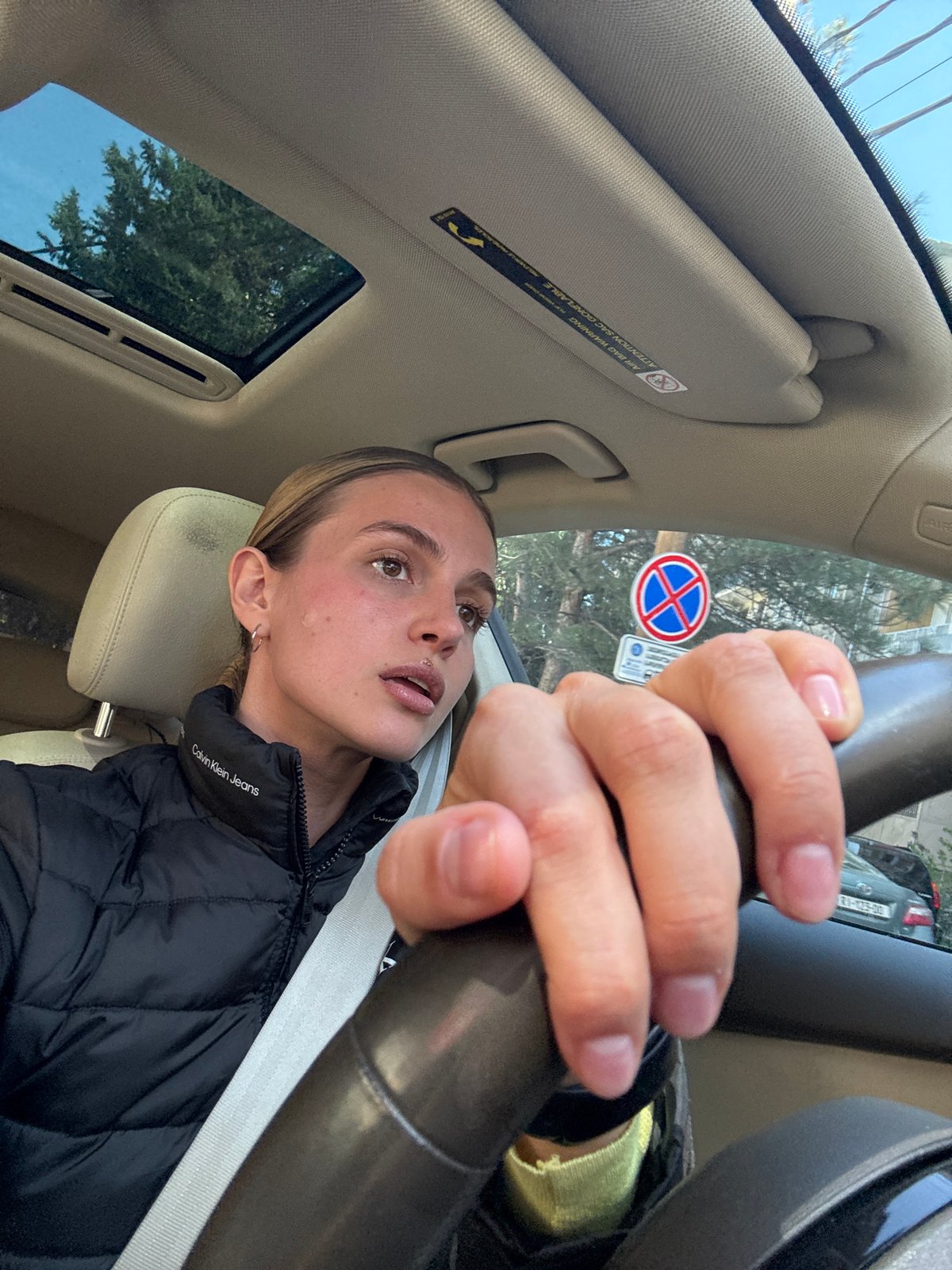 Woman drives car in Tbilisi wearing Calvin Klein jacket