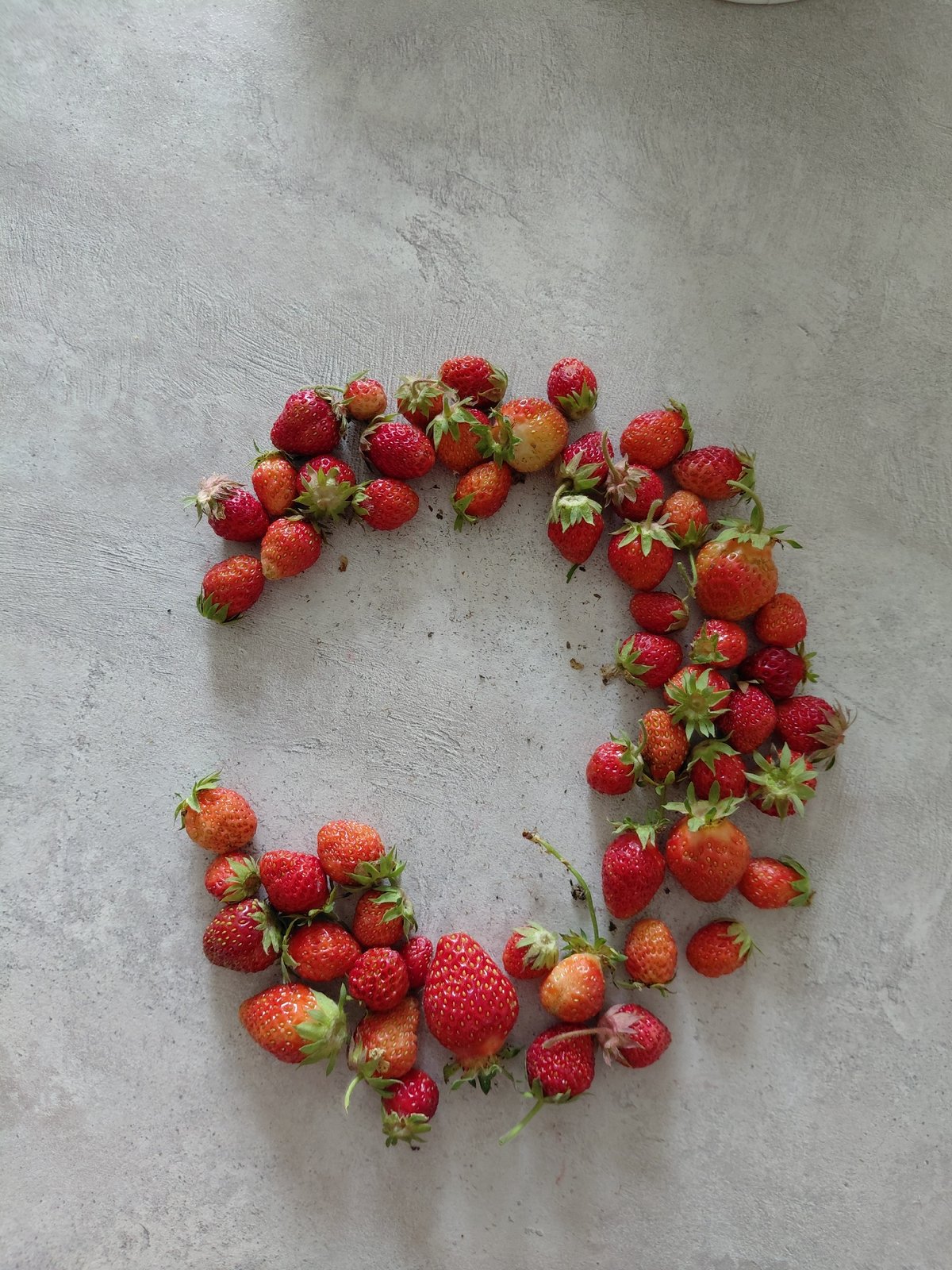Raffaello chocolates and fresh strawberries styled on a gray surface