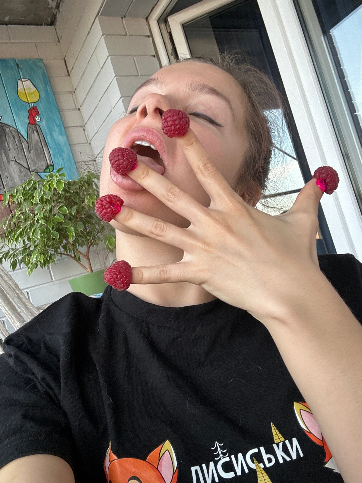 Person plays with raspberries on fingers in Vladimir