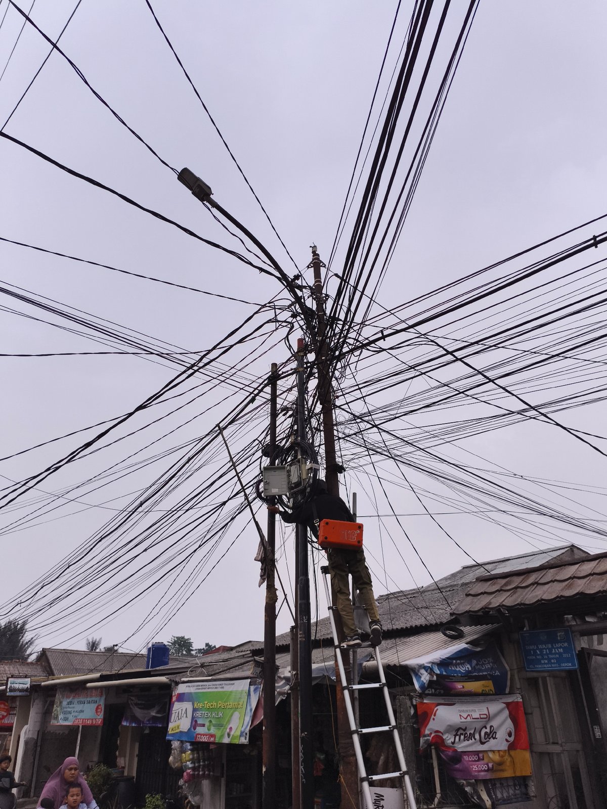 Utility worker repairs power lines in Depok, Indonesia