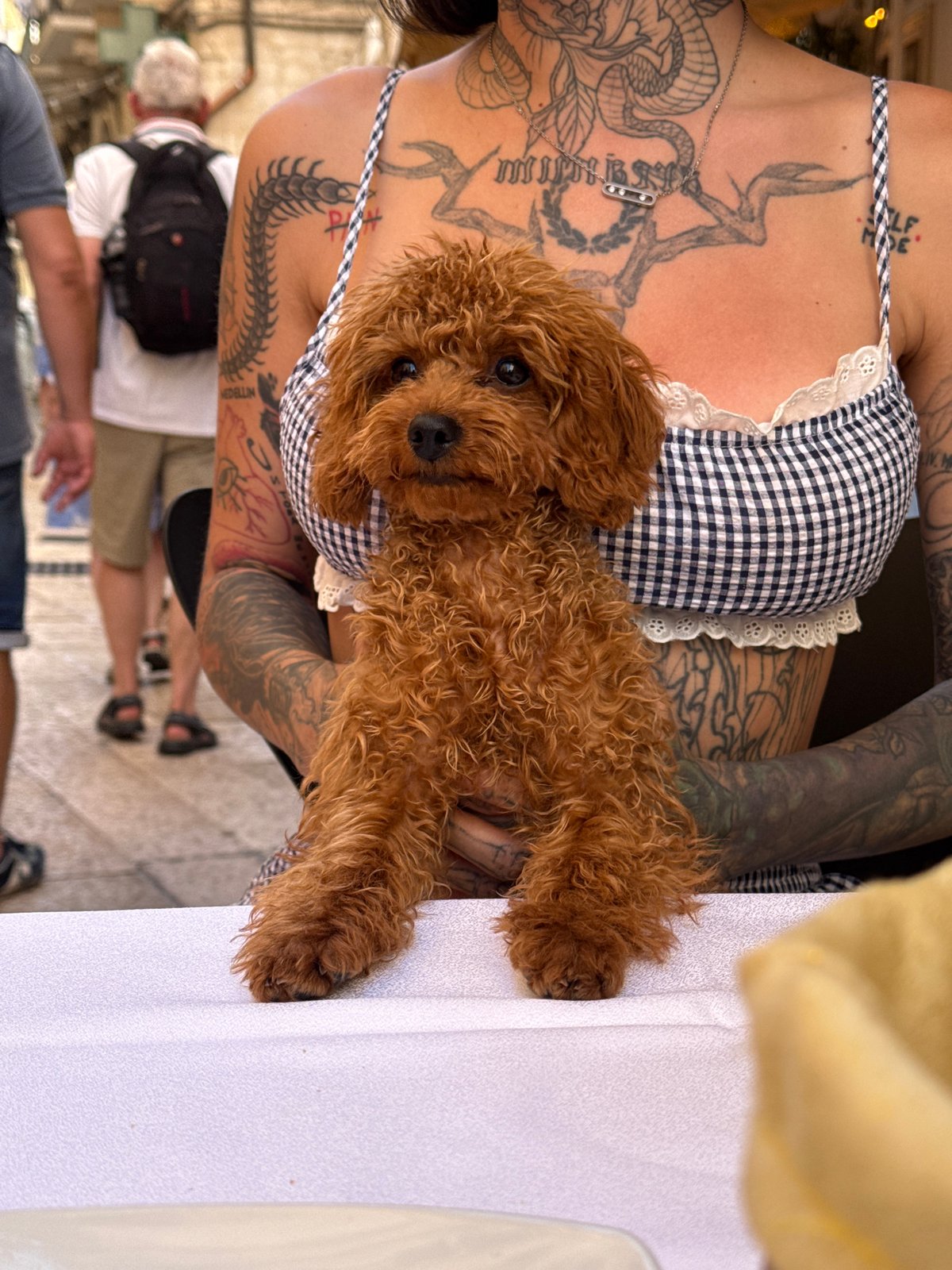 Tattooed woman poses with small dog in Bari