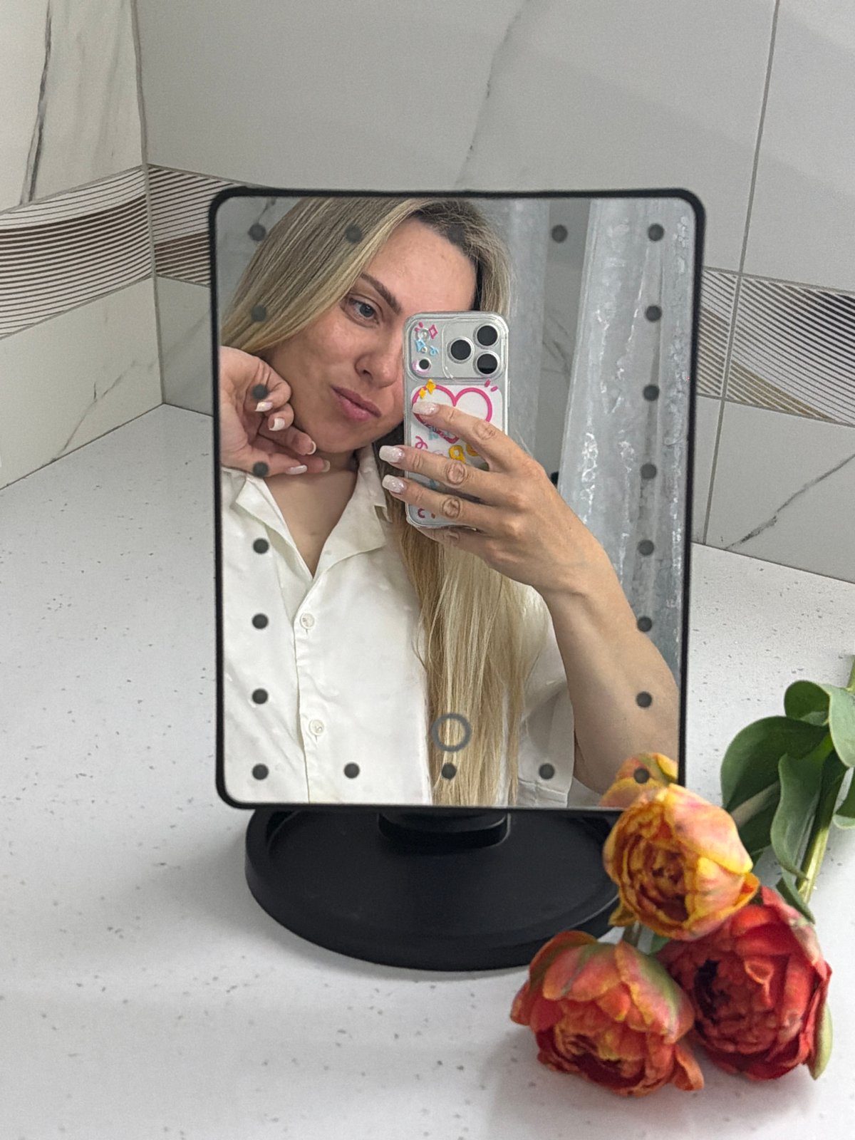 Woman takes bathroom mirror selfies with orange flowers in Votkinsk