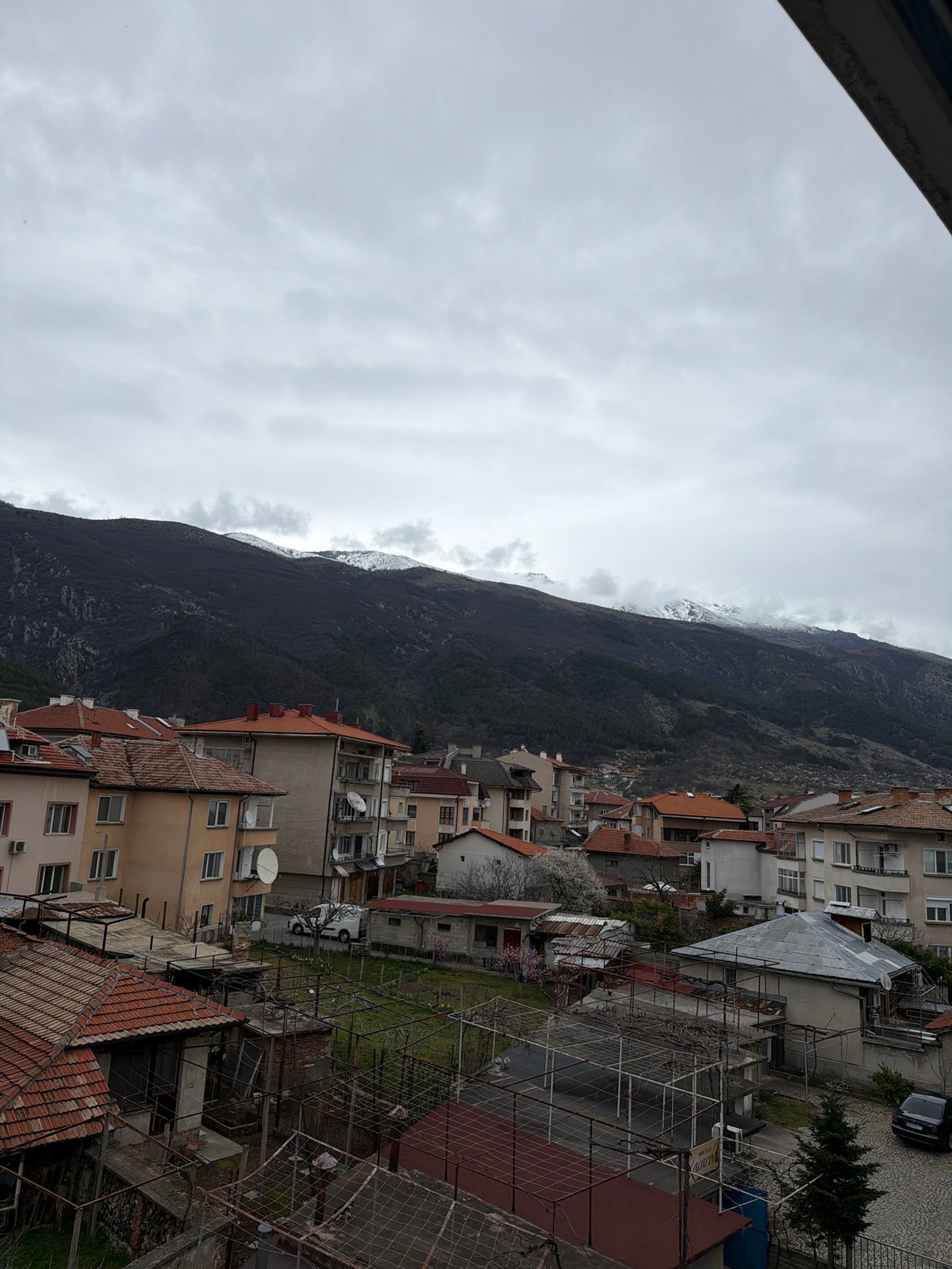 Overcast view captures Karlovo's residential landscape against mountain backdrop