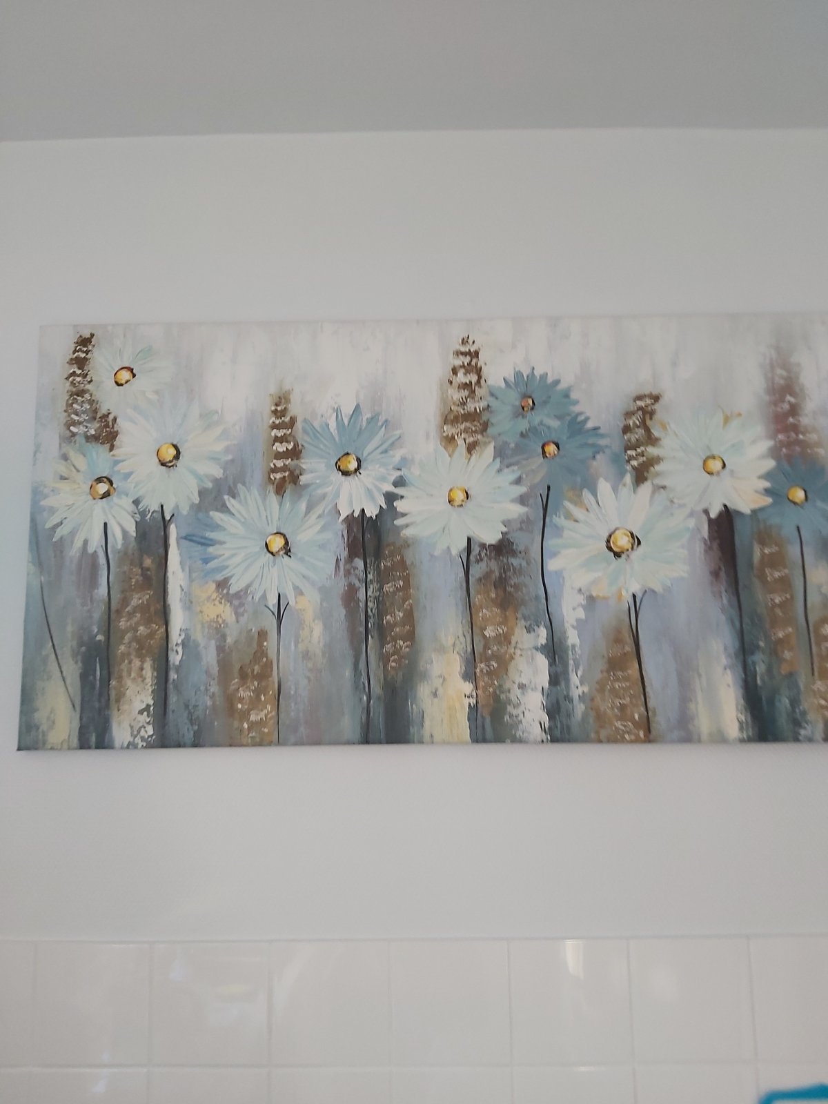 Quiet details of a home interior: art, remote, and flowers