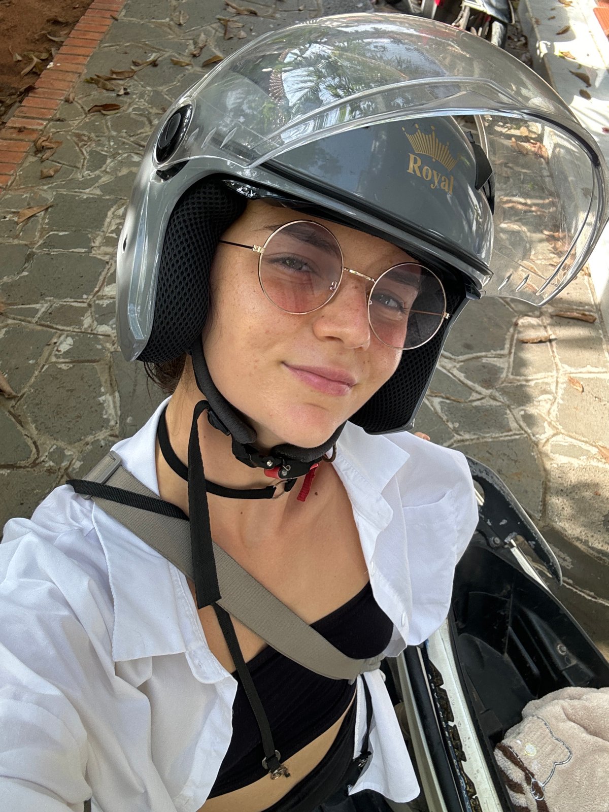 Woman in motorcycle helmet lies on brick surface in Vietnam