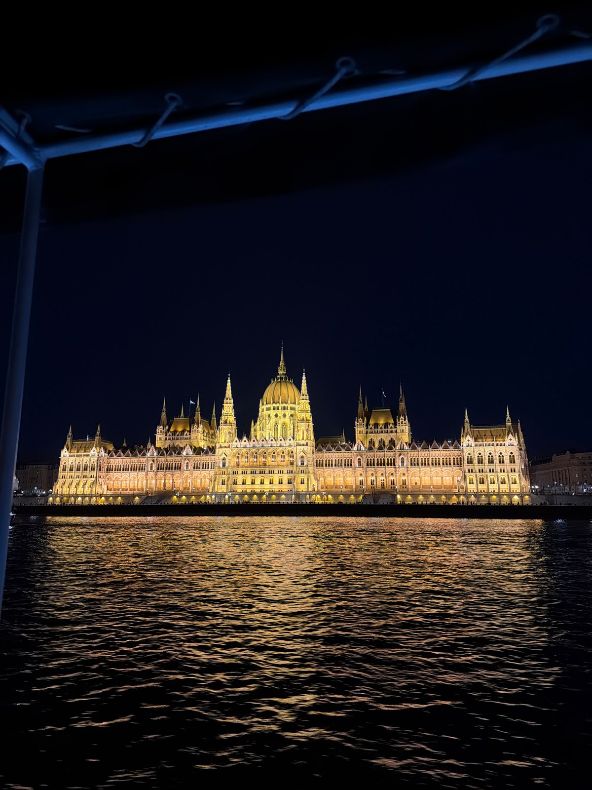 Budapest Parliament Building illuminated at night along Danube River