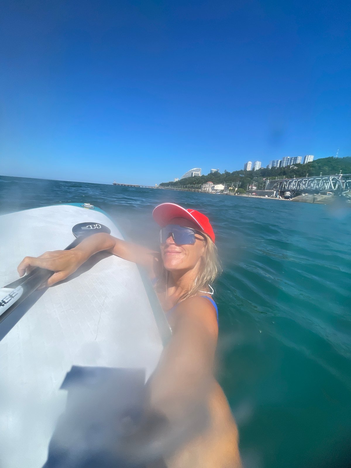 Paddleboarding near a coastal skyline on a calm morning