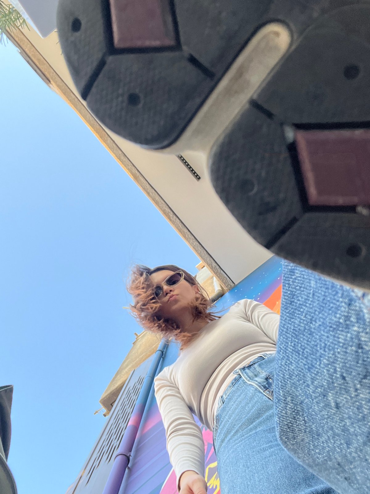 Woman poses for photos near colorful mural in Limassol