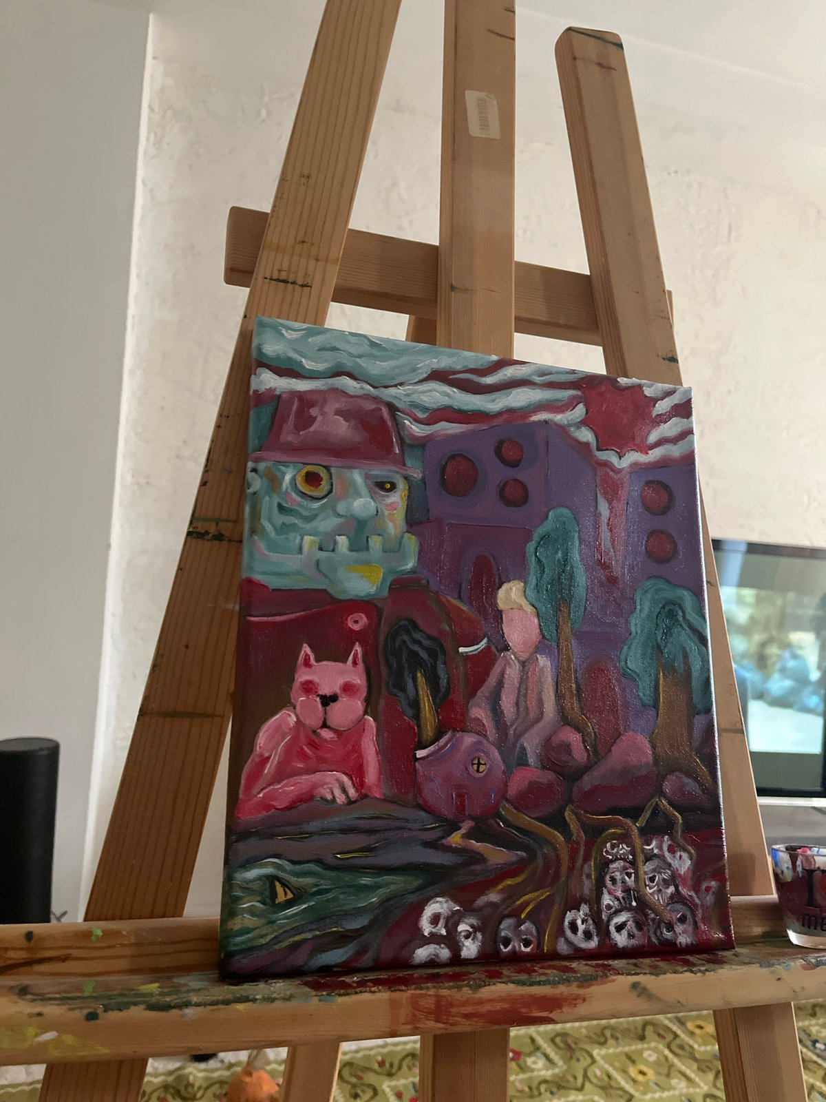 Abstract painting with blue figure, pink cat observed on easel