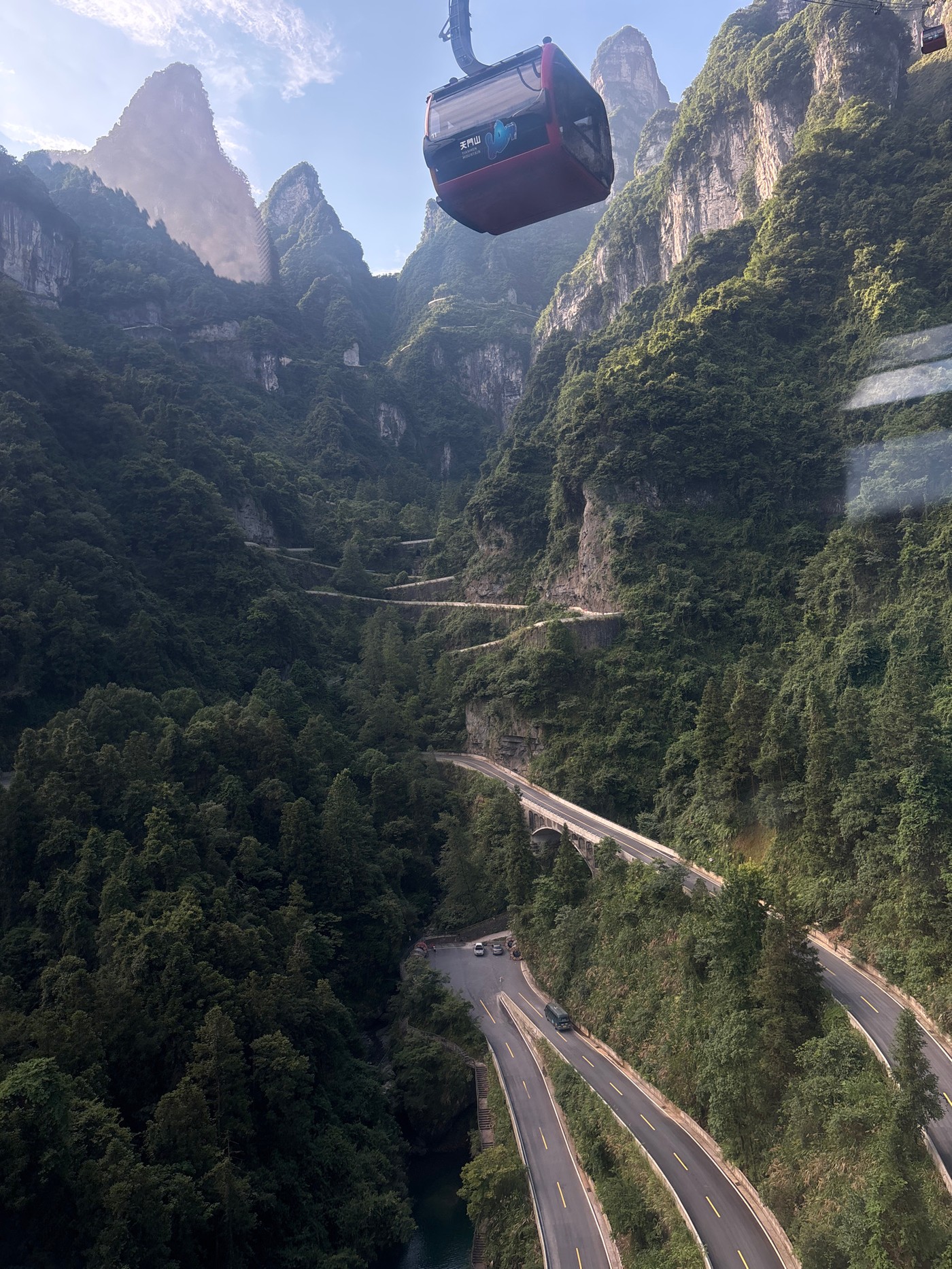 Cable cars crossing steep green peaks at Tianmen Mountain