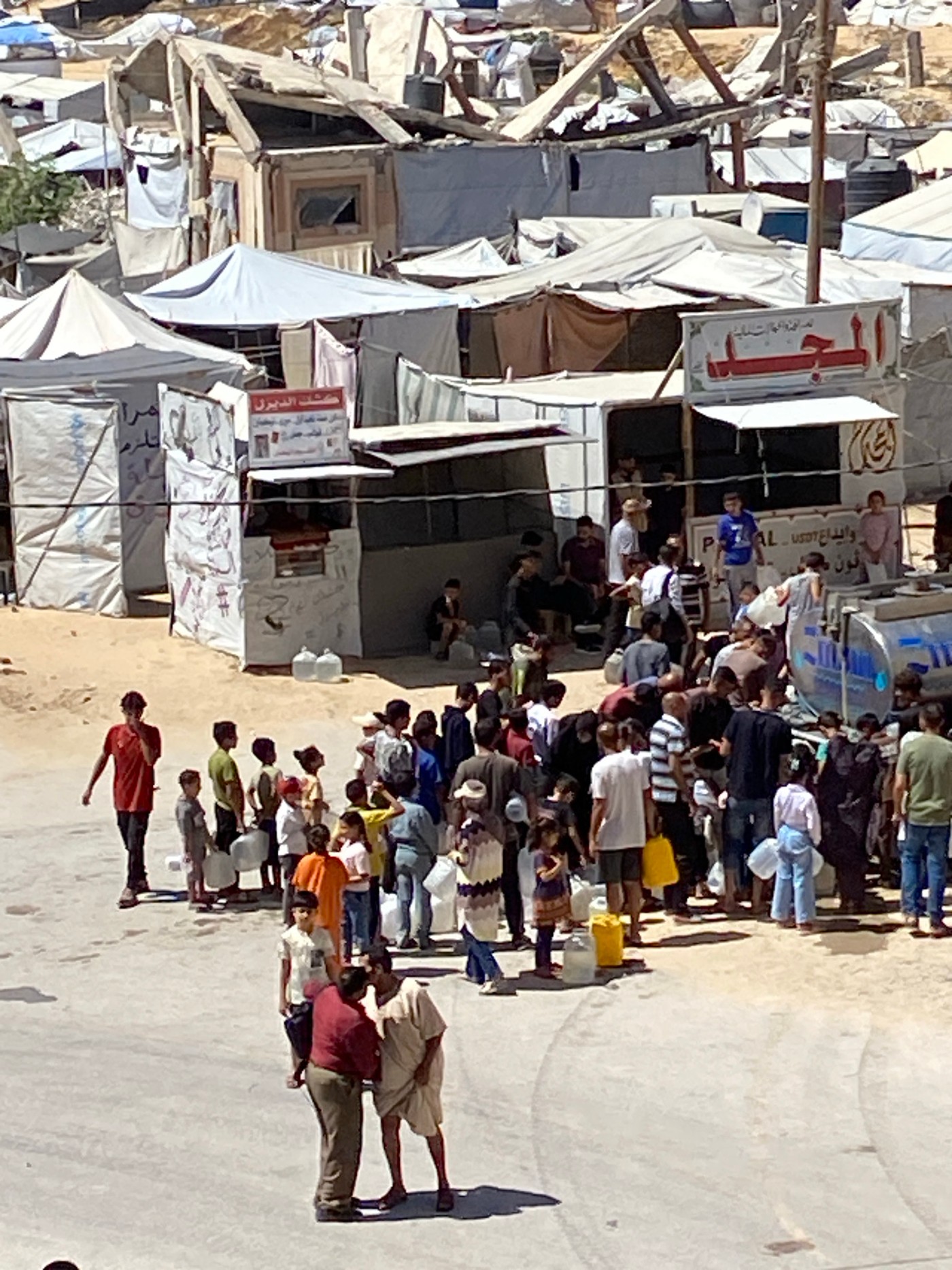 Khan Yunis camp residents line up for water amid crowded makeshift shelters