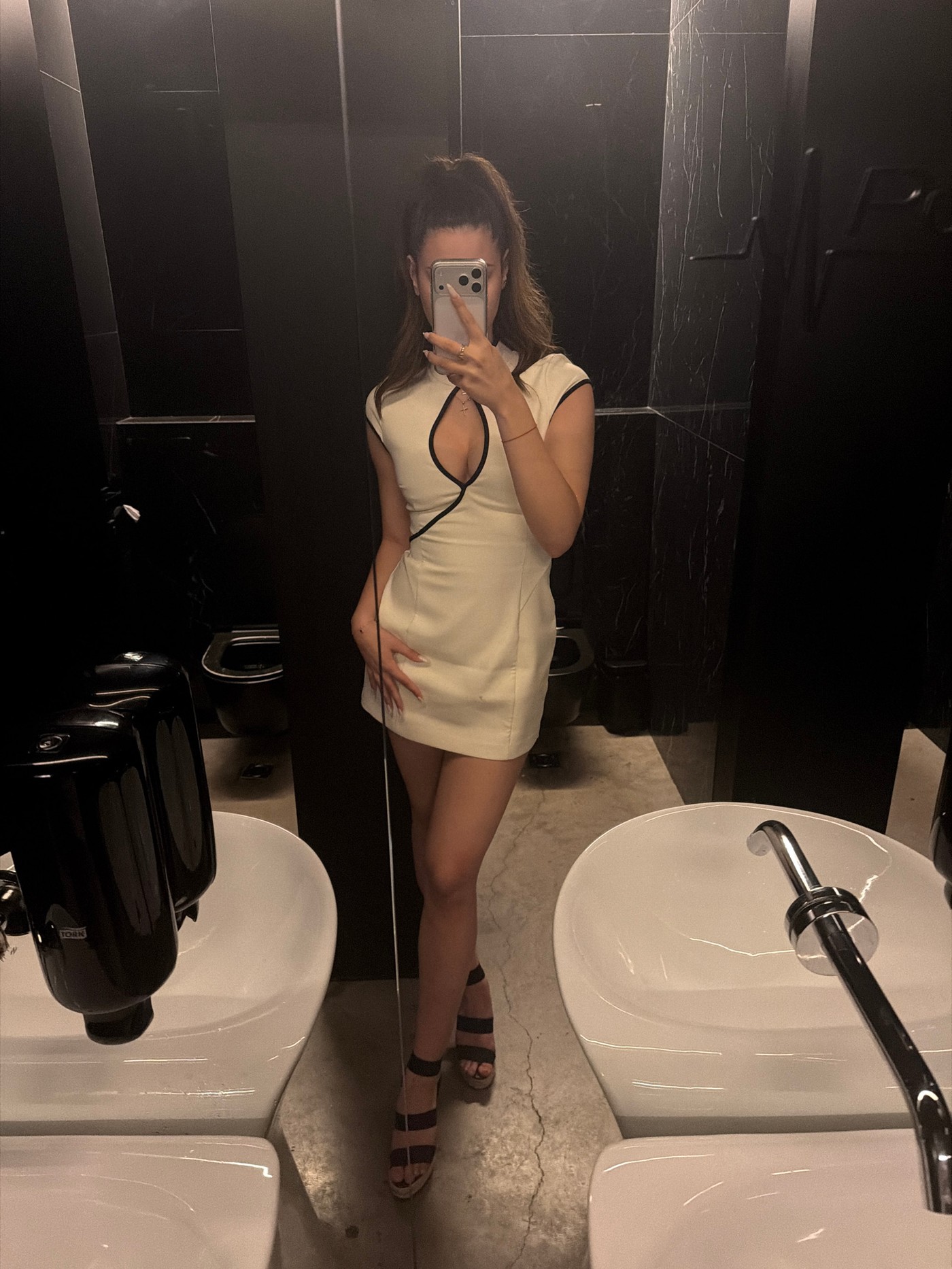 Woman takes mirror selfie in Sofia public restroom