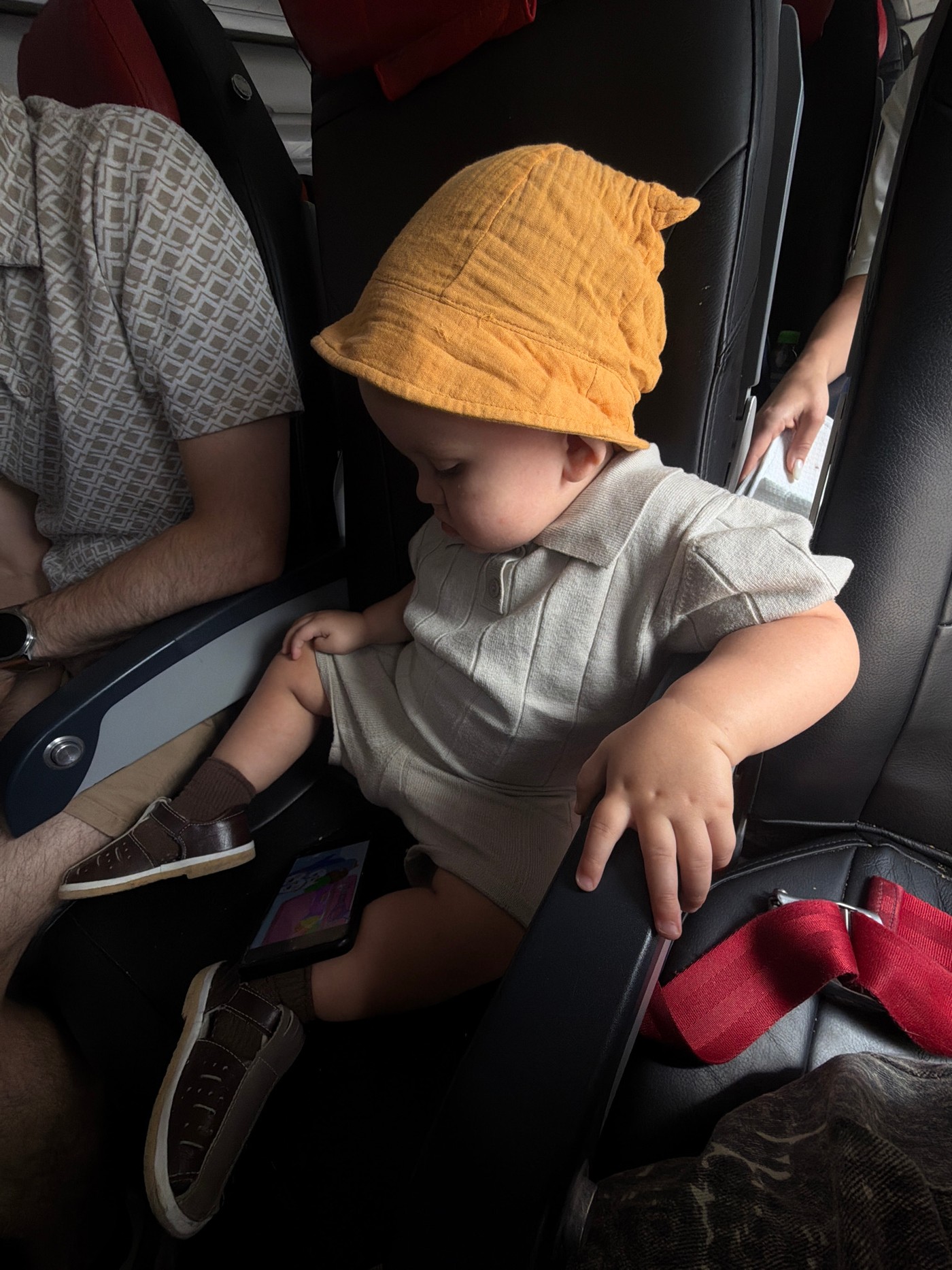 Toddler in orange hat sleeps across airplane seats in Russia