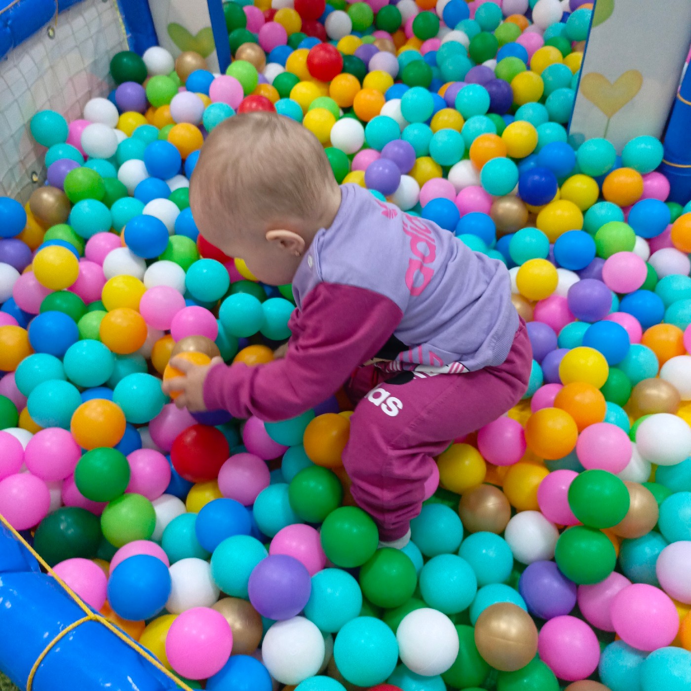 Toddler plays at indoor playground, multiple moments captured