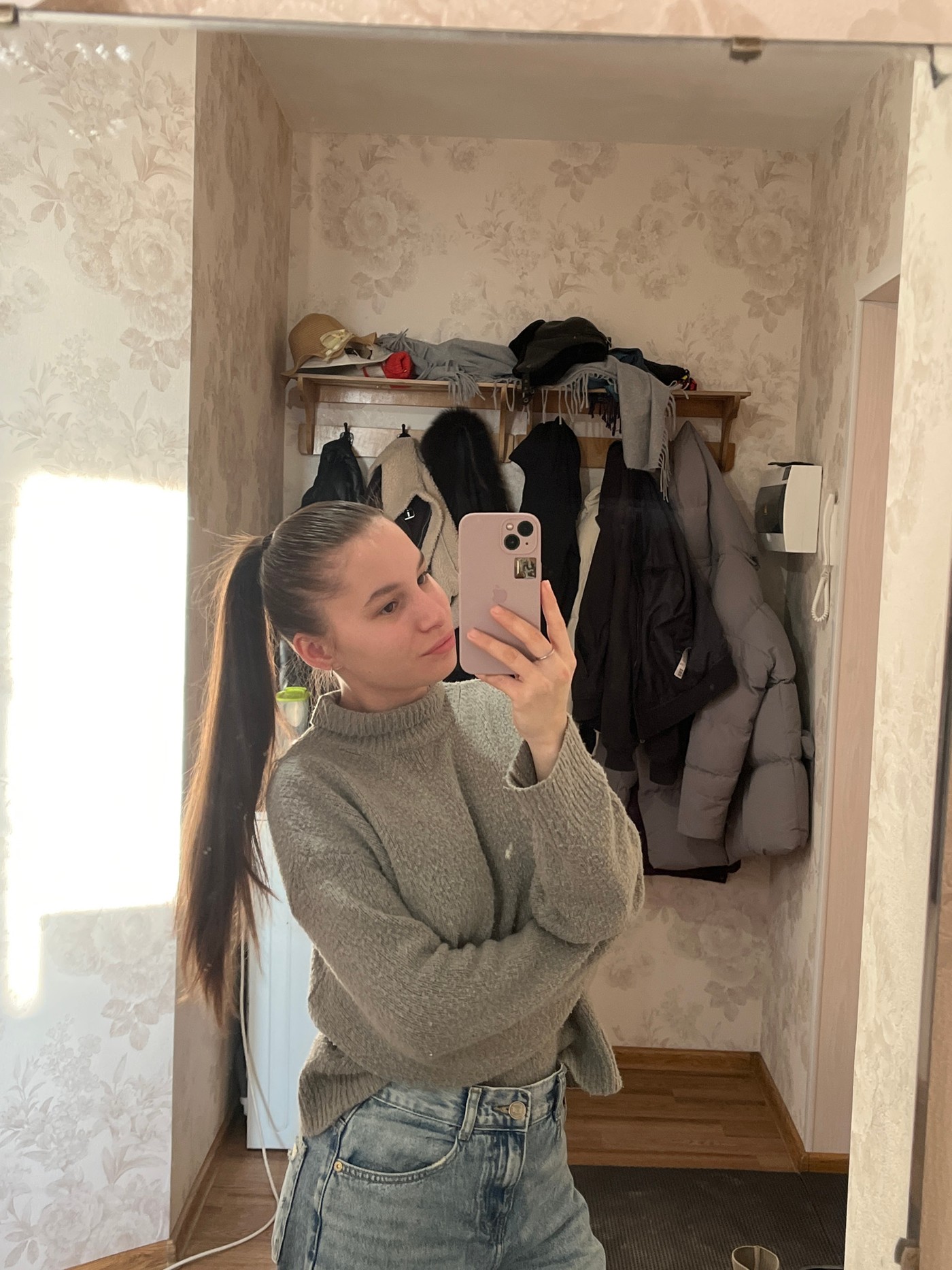 Woman takes selfie in floral wallpapered room in Chaikovsky