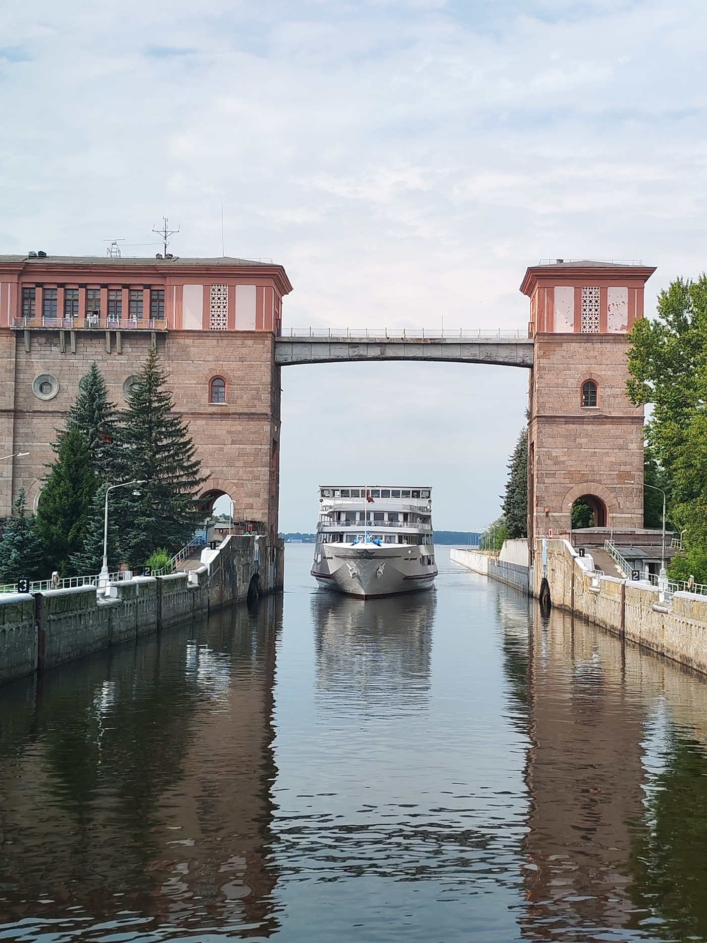 River cruise ship passes through a brick lock on a Russian canal.