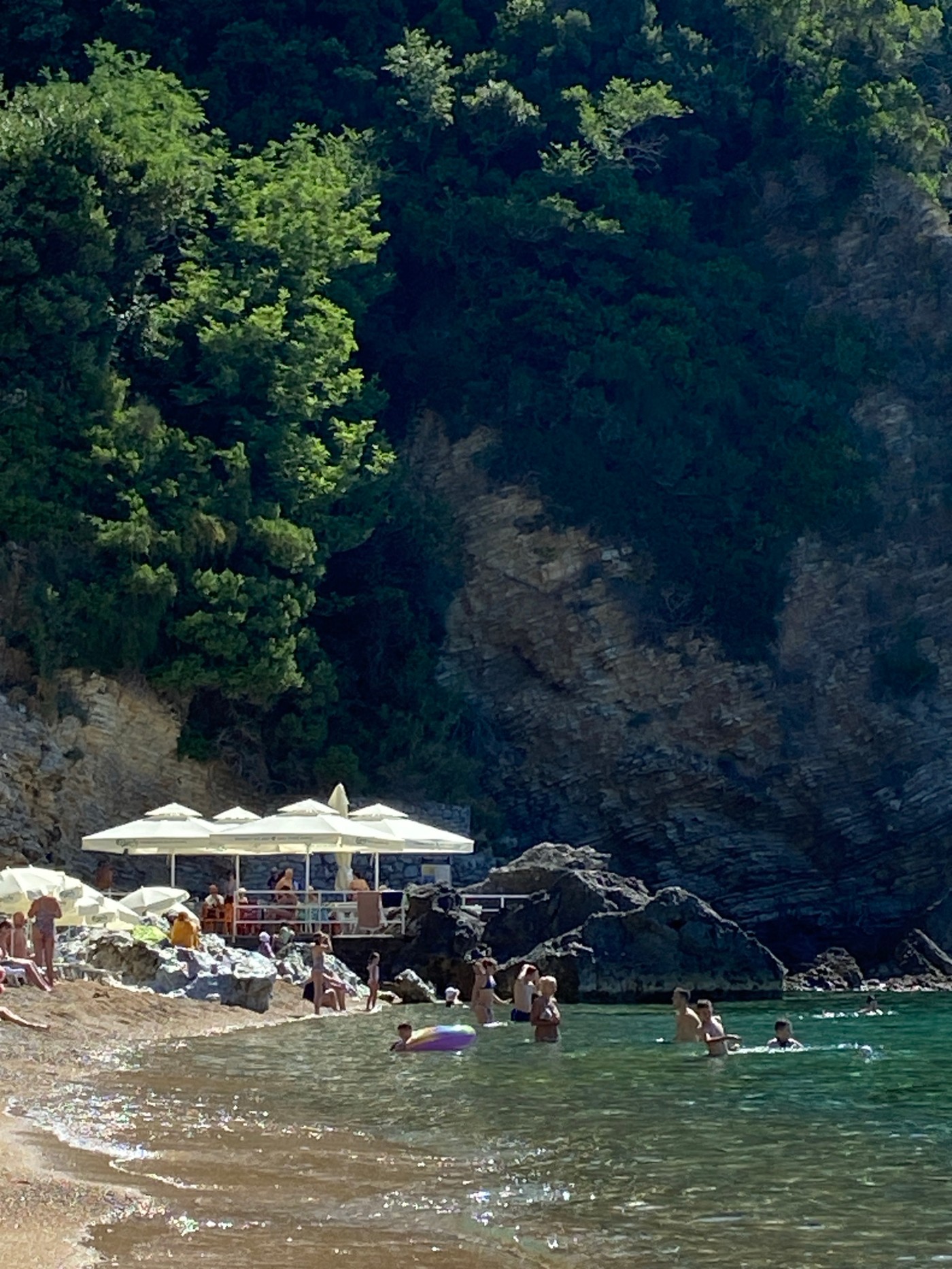 Sunny morning on Budva's beach, coastline and rentals in view