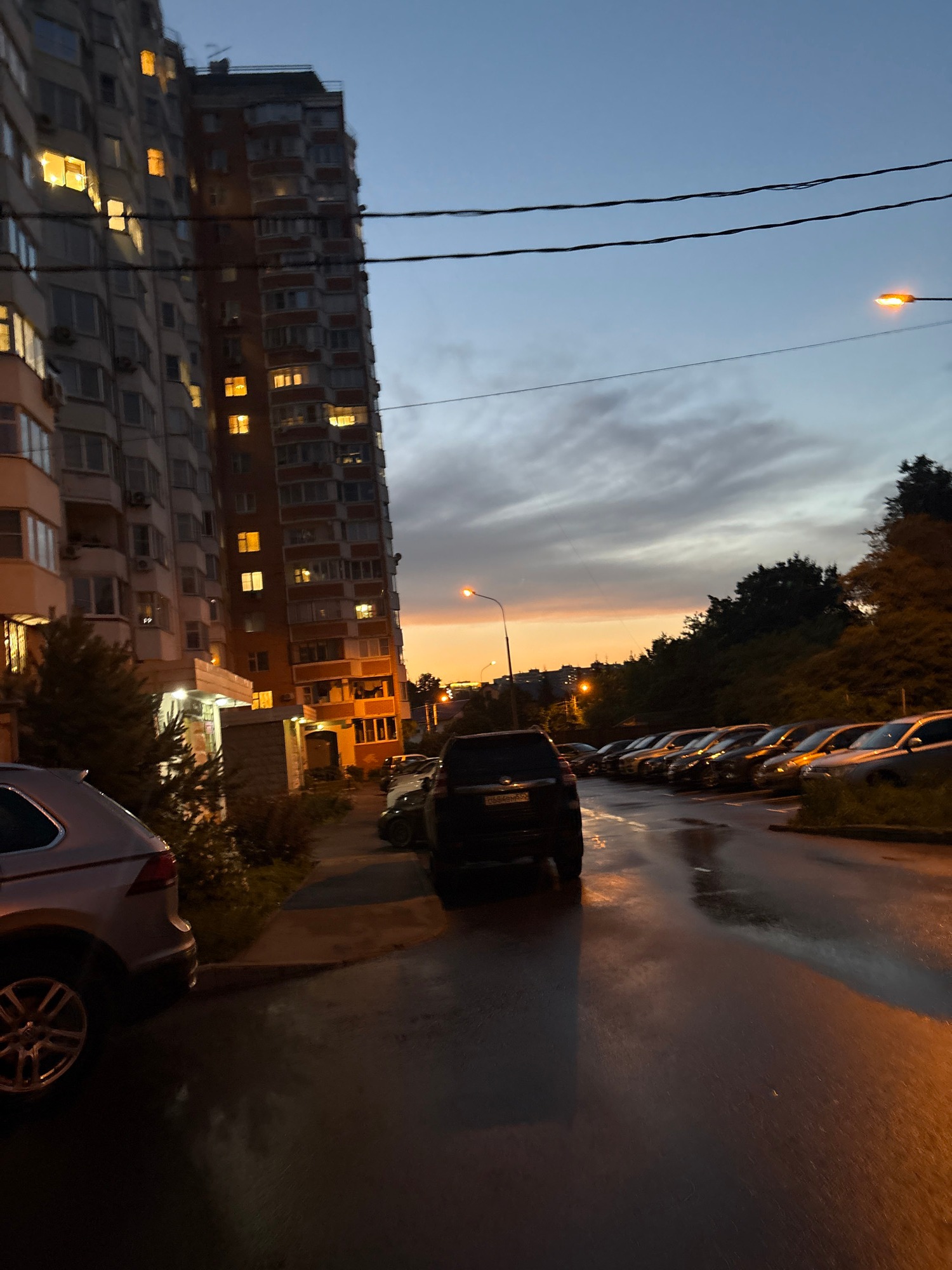 Rainy dusk hangout outside an urban apartment building