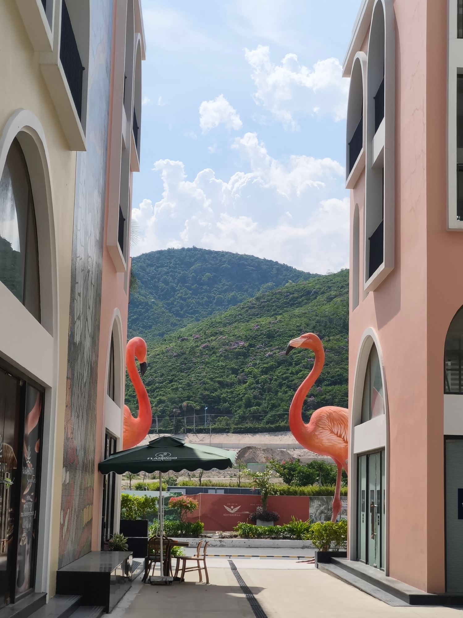 Flamingo statues, a pink car, and coastal scenery on a sunny morning