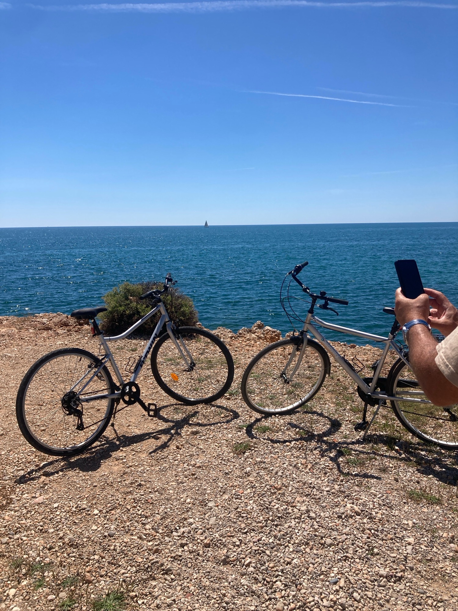 Cyclists pause for photos at scenic coastal cliff overlook