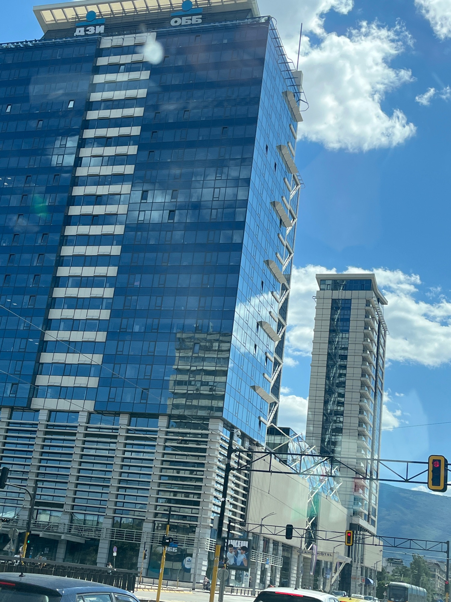 Glass skyscrapers rise against a bright blue sky