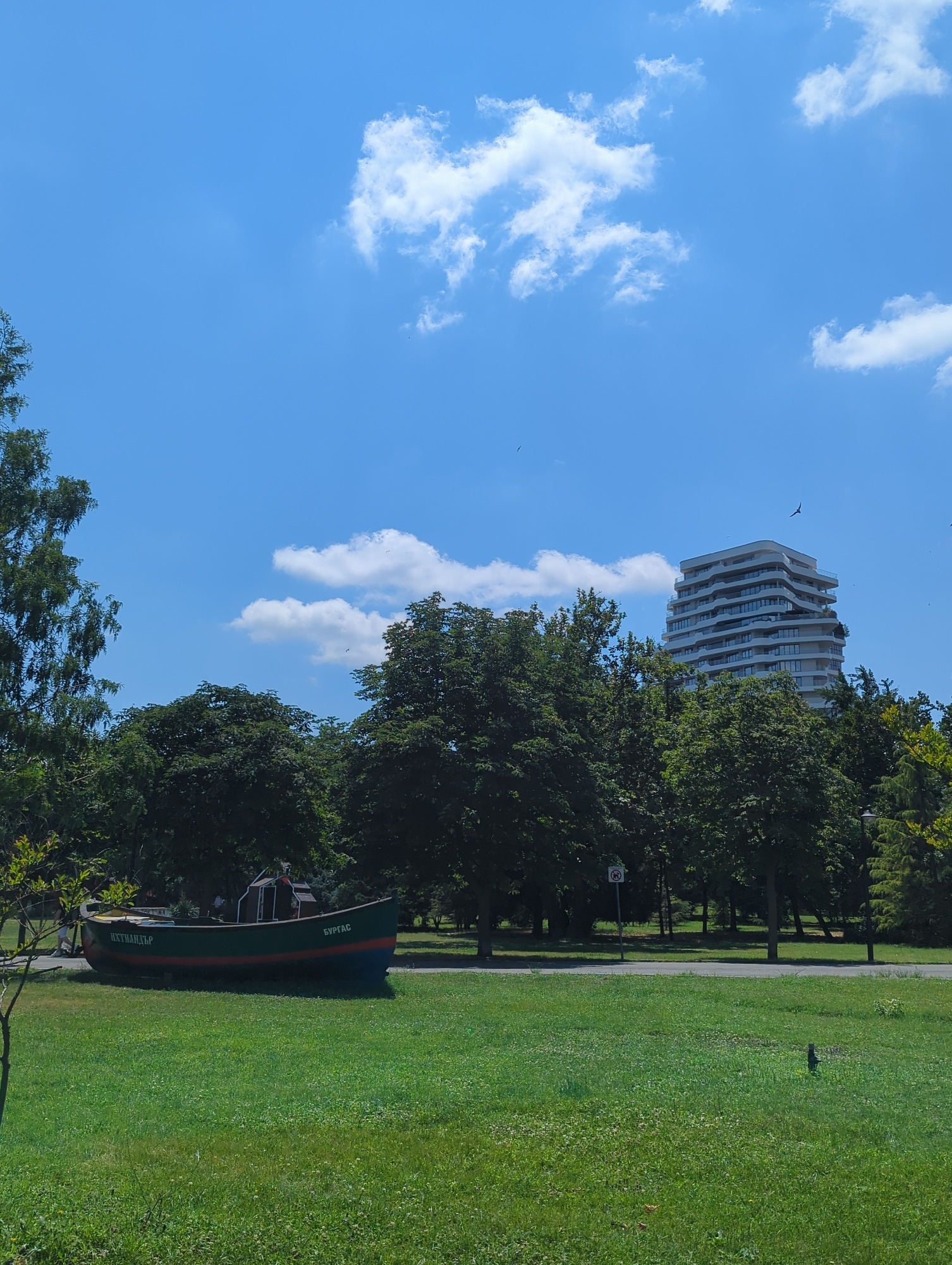 Fishing boat display and parked cars in an urban park setting