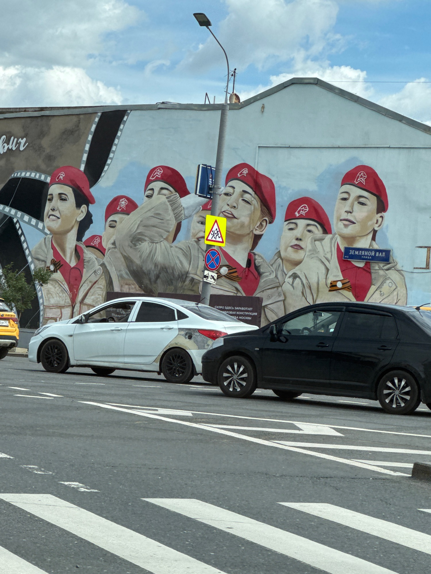 Bold mural of figures in red berets covers a building wall