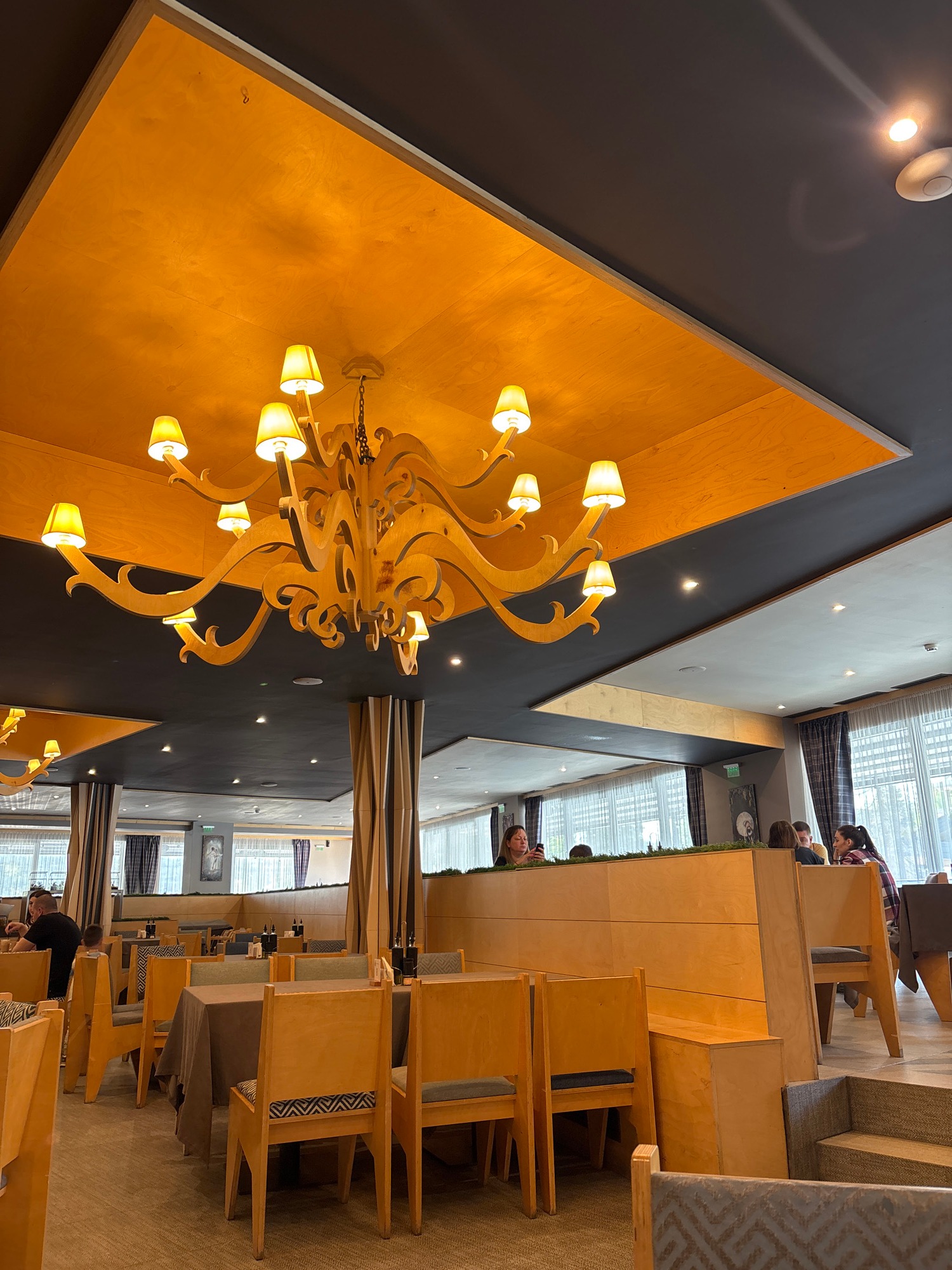 Restaurant interior with ornate wooden chandelier documented by witness