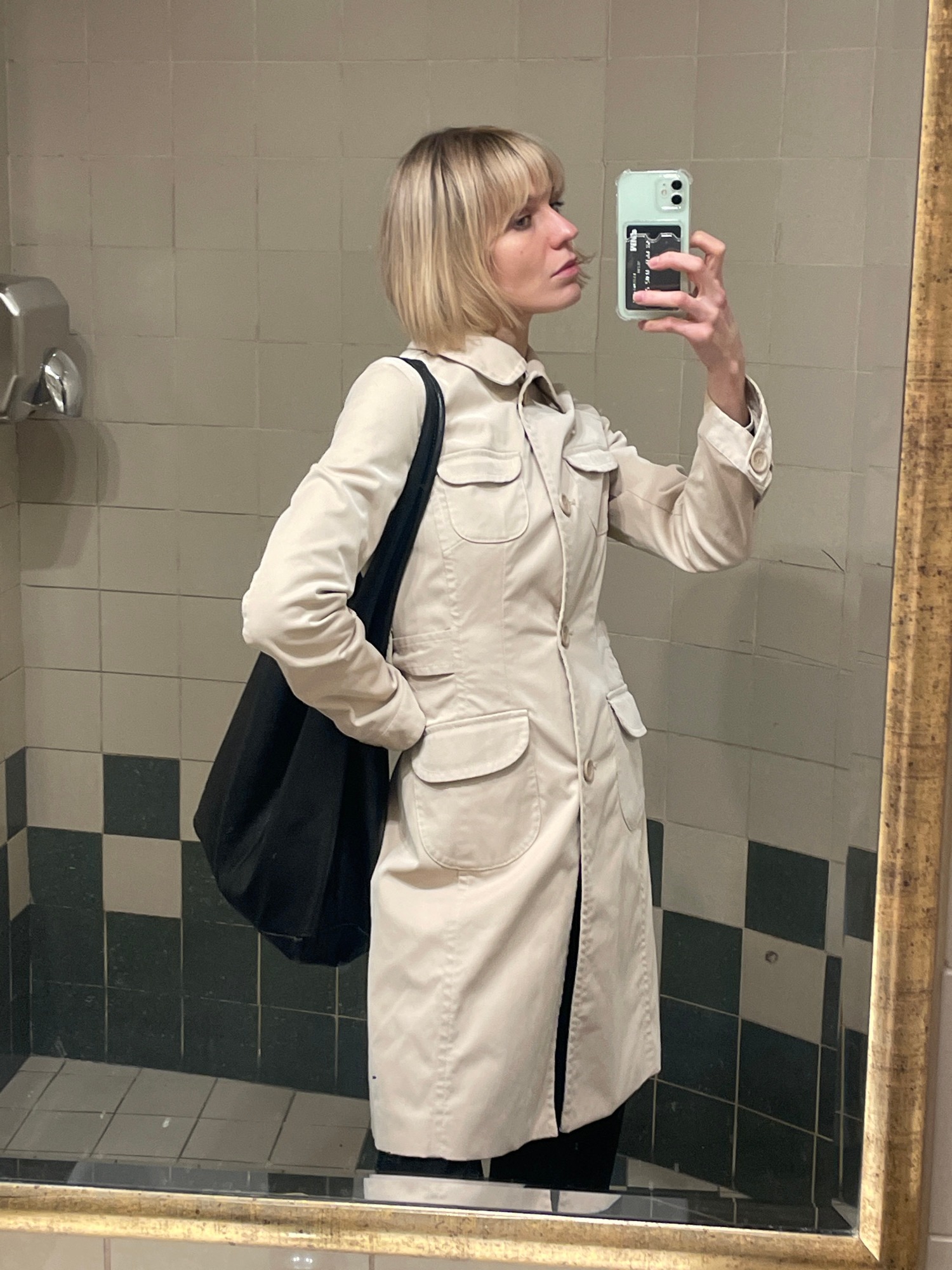 Person takes mirror selfie indoors, blonde hair visible
