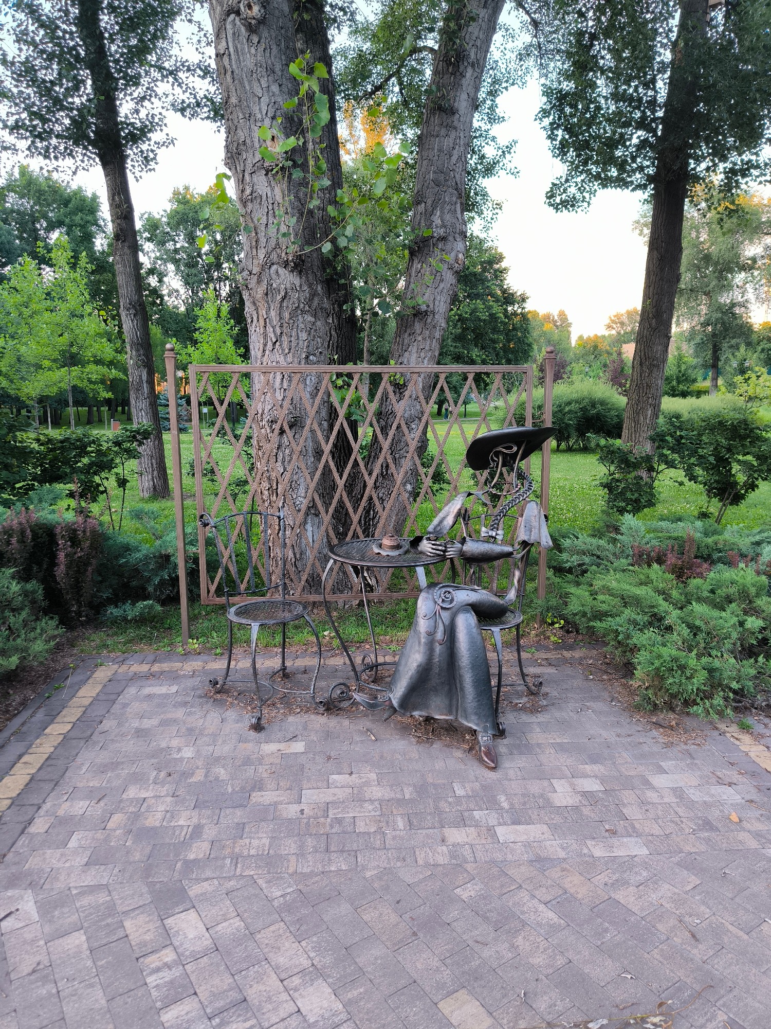 Sunny afternoon in the park: dog walks, strolls, and a metal sculpture