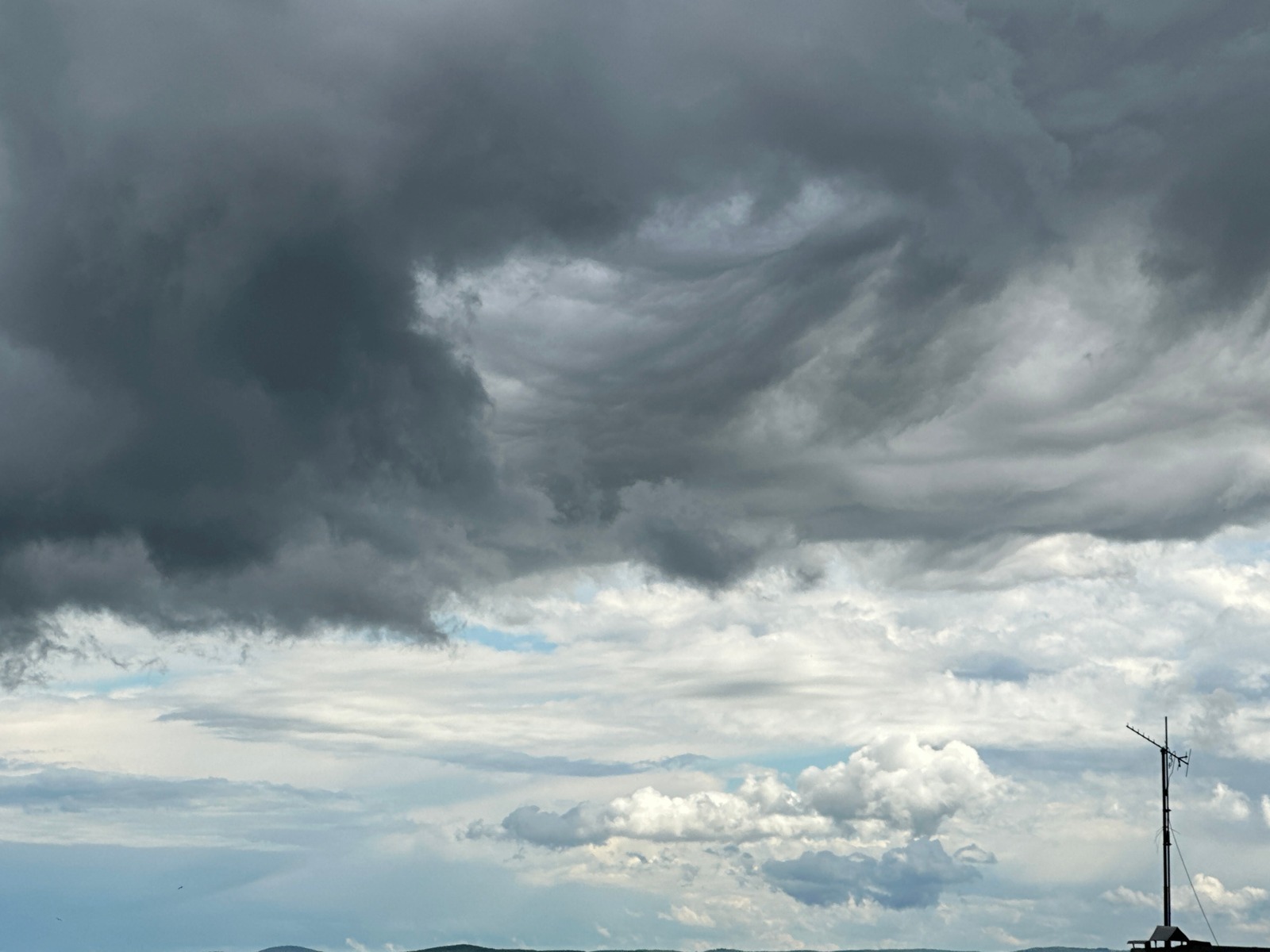 Storm clouds gather over rural landscapes and cities