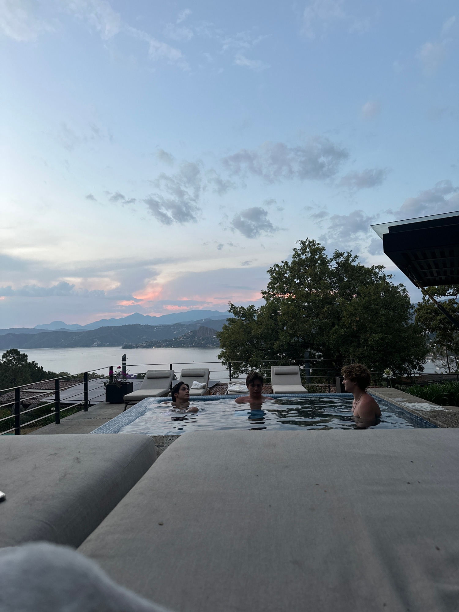 People swim at scenic mountain lake overlook during sunset