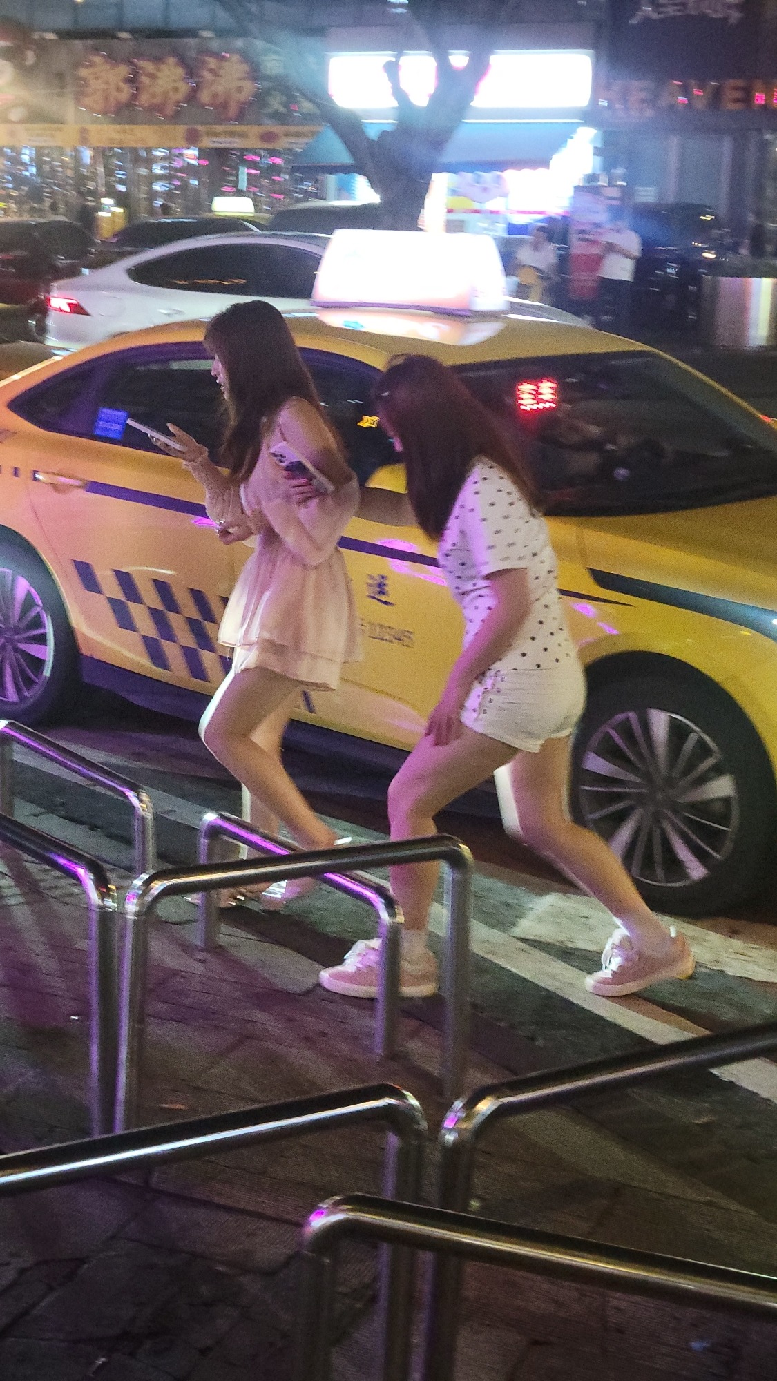 Nighttime urban street scenes with pedestrians and taxis documented