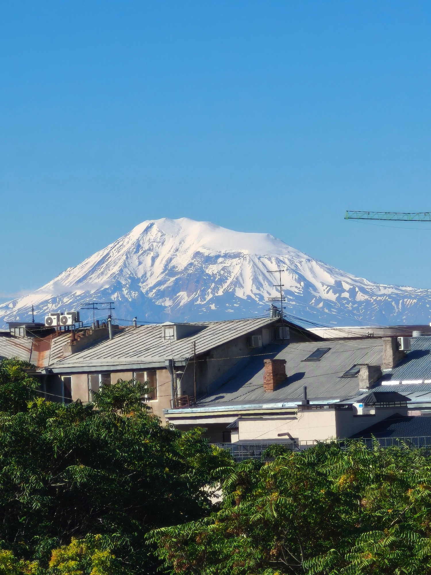 Snow-capped Mount Ararat looming over a Turkish city skyline