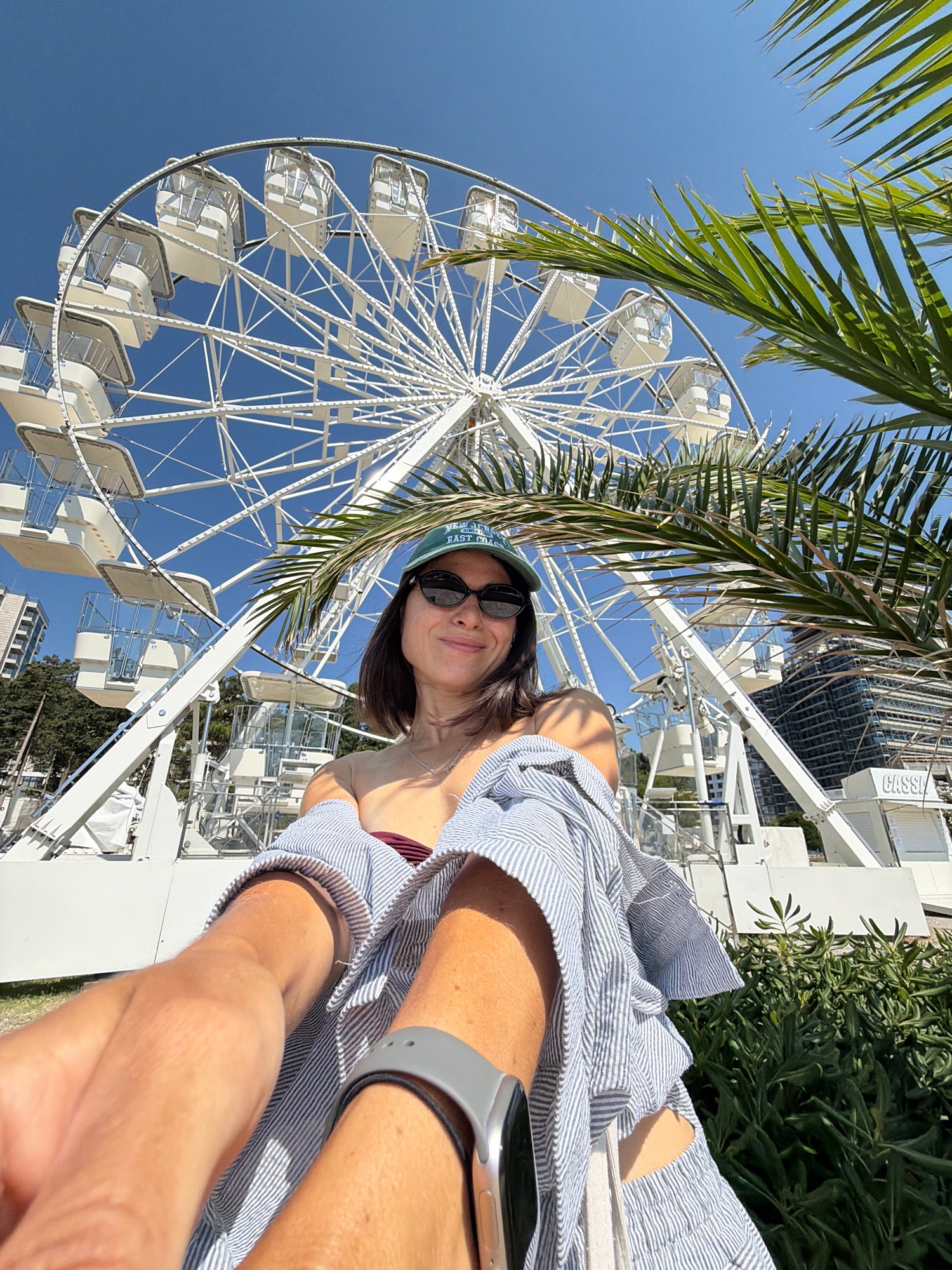 Selfie session at a white Ferris wheel by the water
