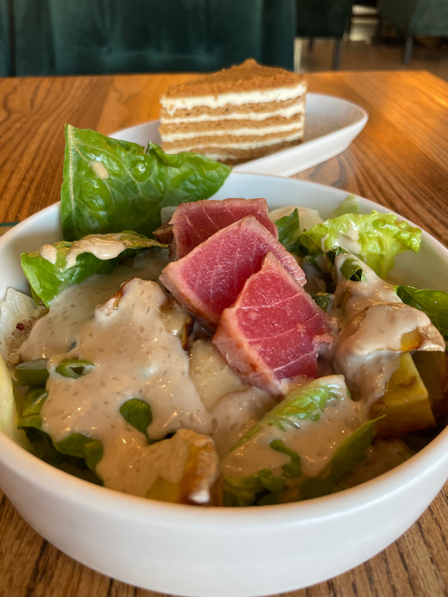 Restaurant meal with grilled sausages, tuna salad and cake