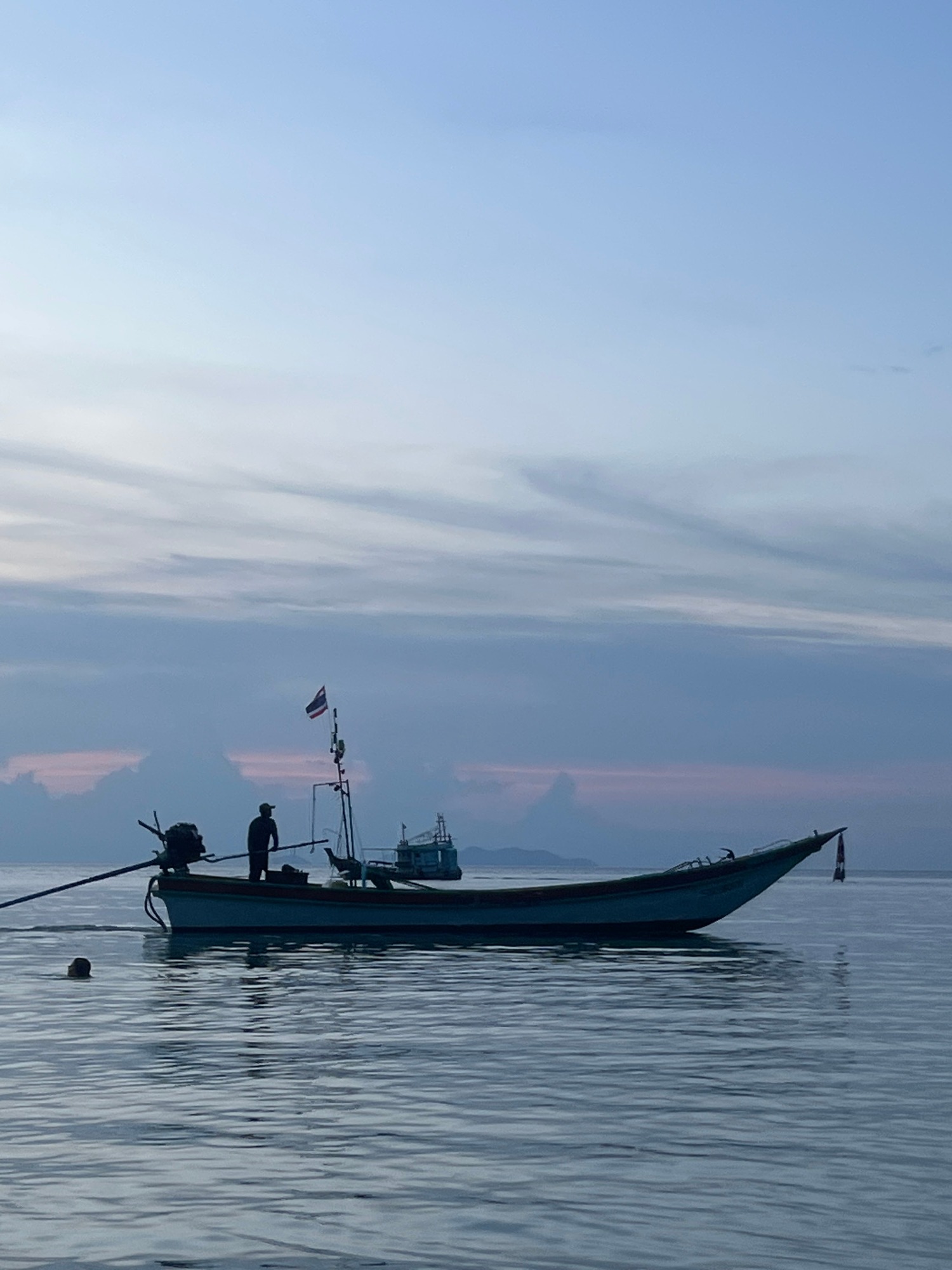 Dusk on a tropical coast, longtail boats and still water