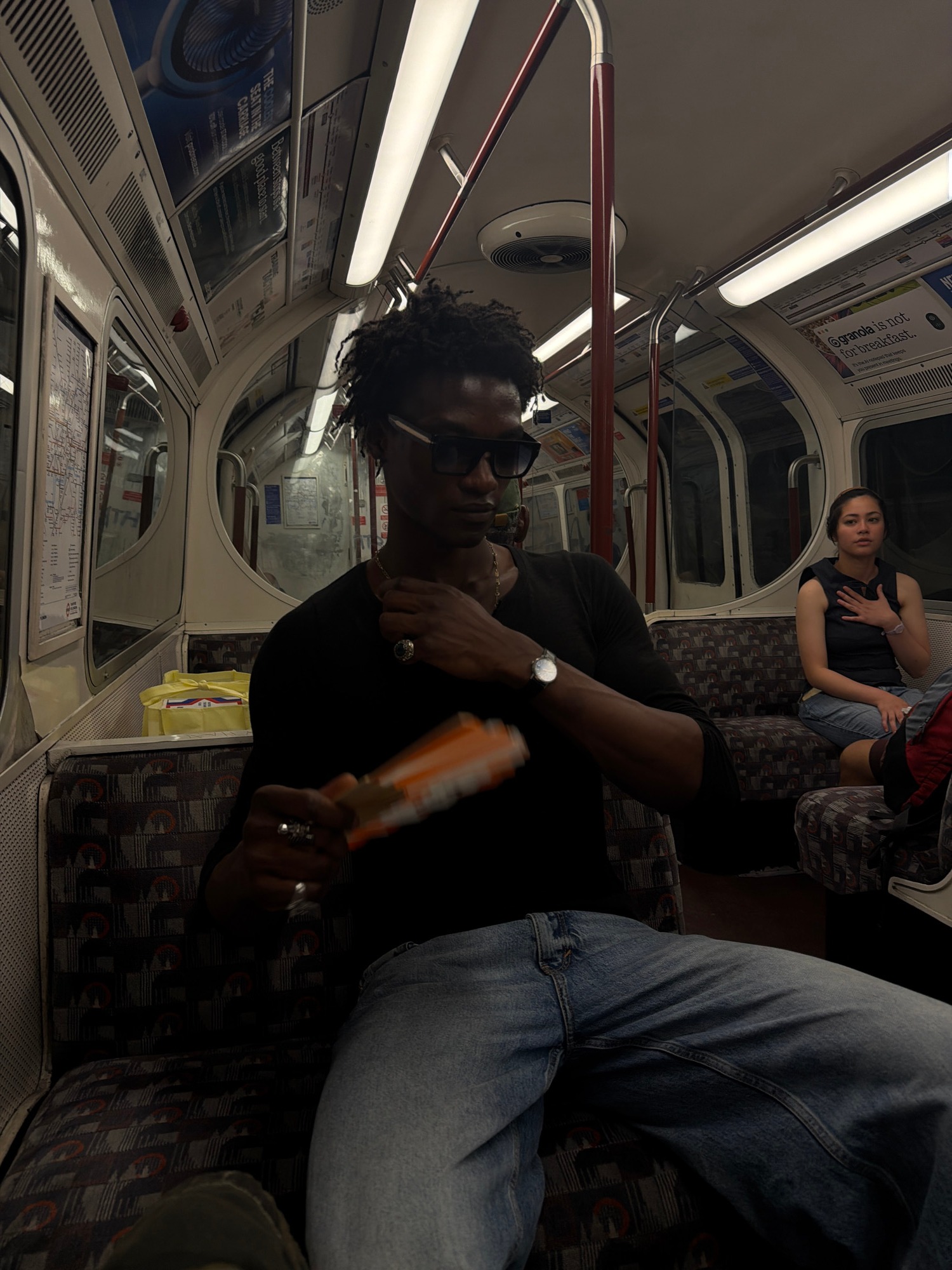 Two riders on a dimly lit subway car