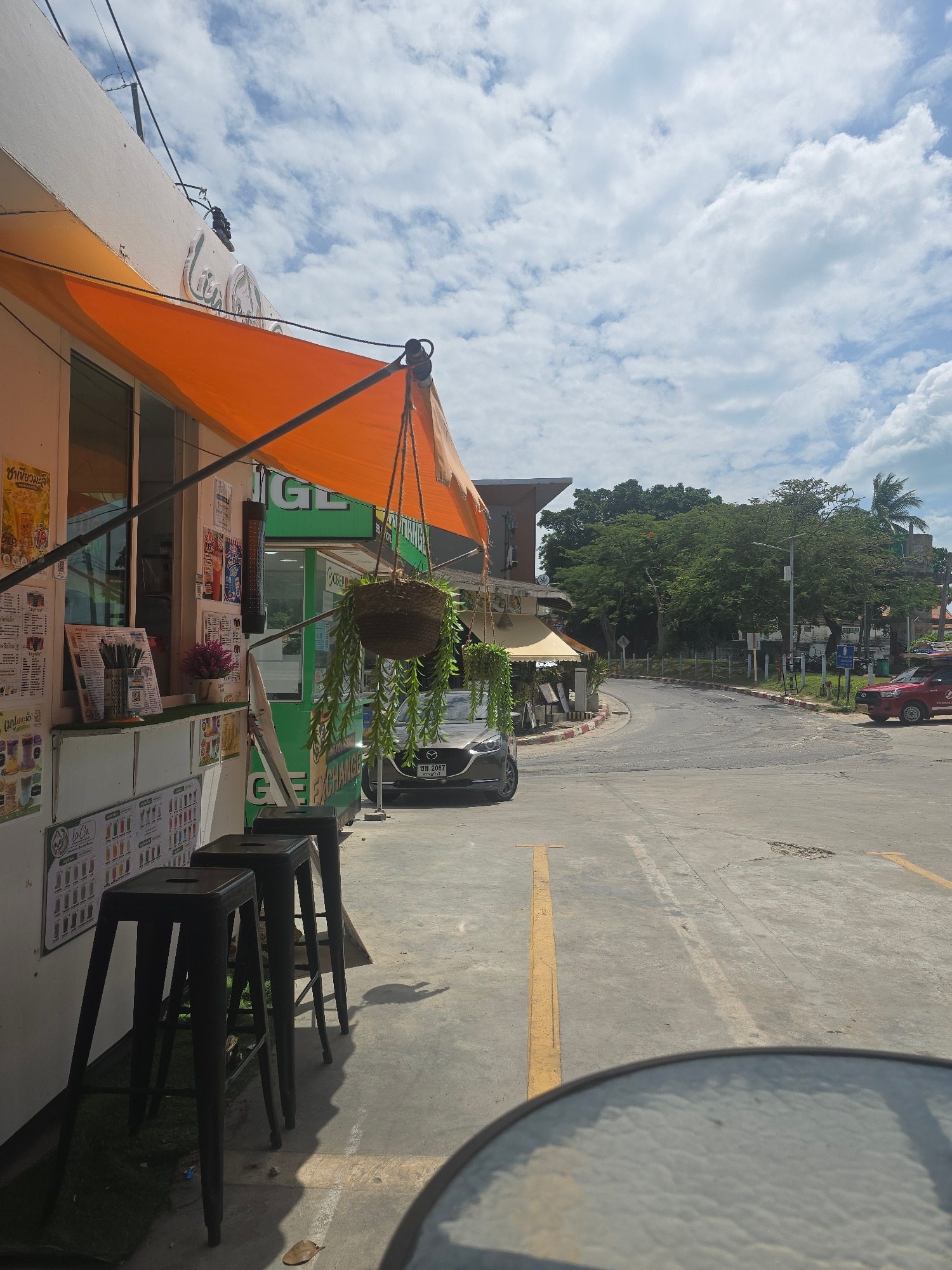 Busy Thai tourist street: scooters, kiosks, and everyday traffic
