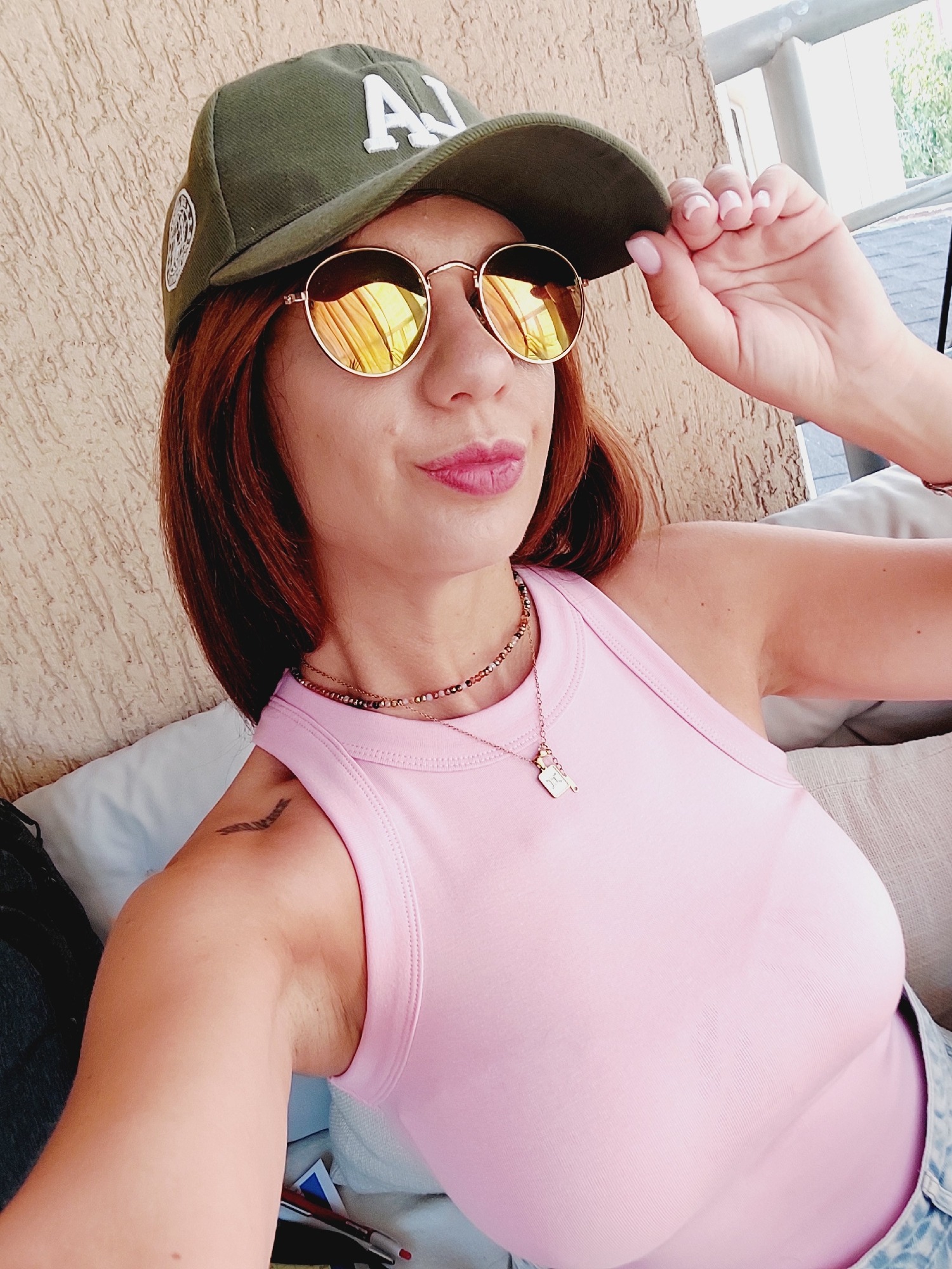 Green LA cap and pink tank top across multiple selfies
