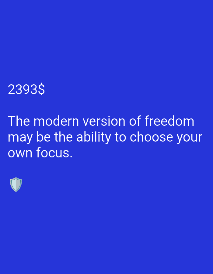 The media is a digital image with a solid blue background. In the top left corner, the text "2393$" is displayed in a large, white font. Below this, a quote in white text reads: "The modern version of freedom may be the ability to choose your own focus." At the bottom left of the image, there is a small, light blue shield icon. There are no people or a specific scene depicted, and the setting is abstract due to the plain background. The overall tone is one of contemplation or motivation, suggested by the quote.