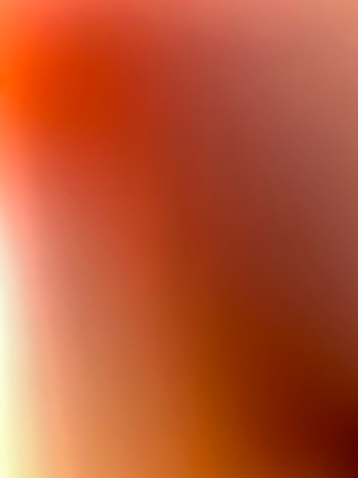 This media file is a softly focused, abstract image dominated by warm, gradient colors ranging from a muted reddish-brown in the upper left to a bright orange and yellow in the lower right. There are no discernible subjects such as people, objects, or a specific scene. The smooth transition of colors suggests a blurred background or a deliberate artistic choice for visual texture rather than representation. There is no clear indication of time of day, weather, location, or emotions, and no visible text.